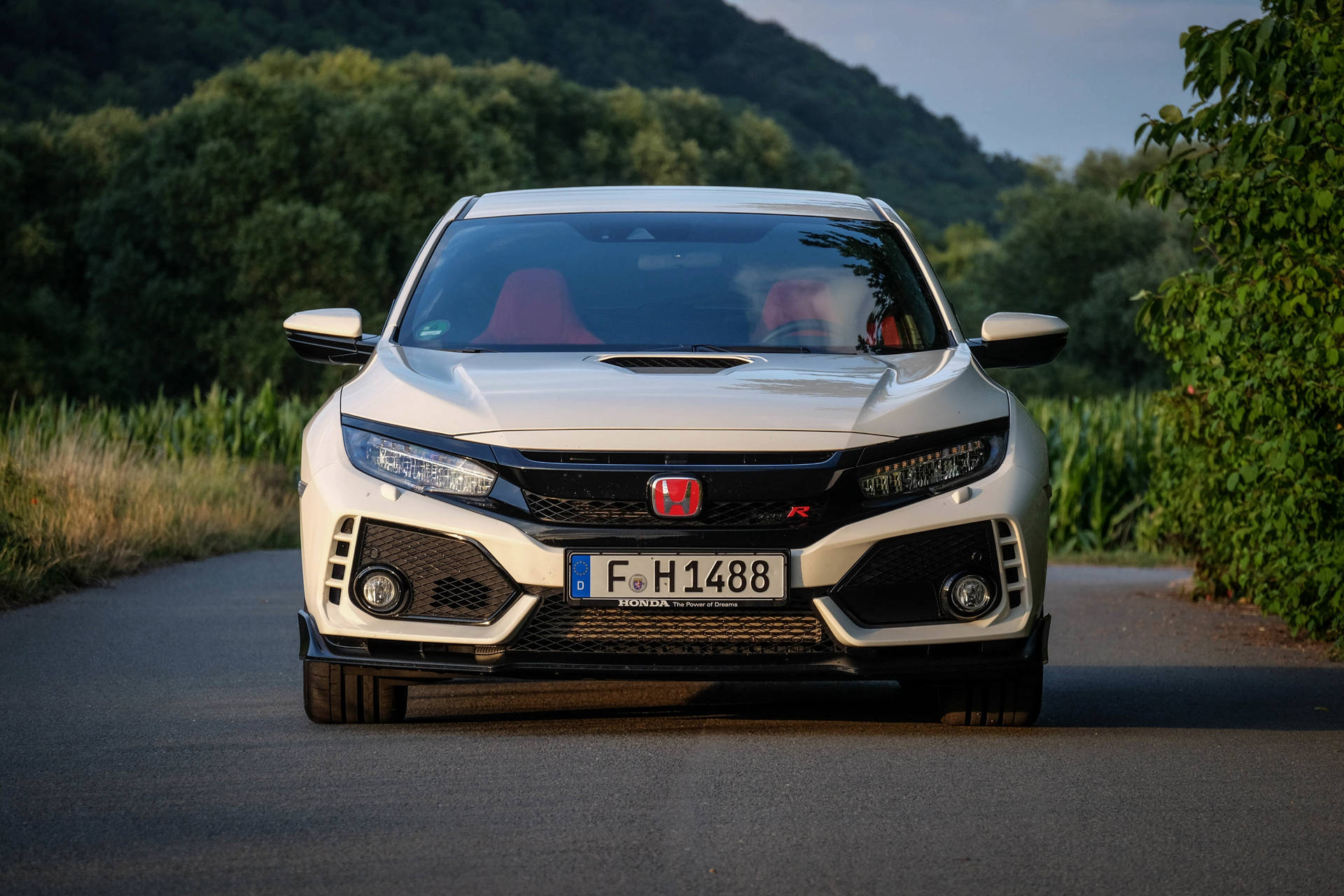 日落時分，白色本田Civic Type R行駛在風景如畫的鄉村道路上。