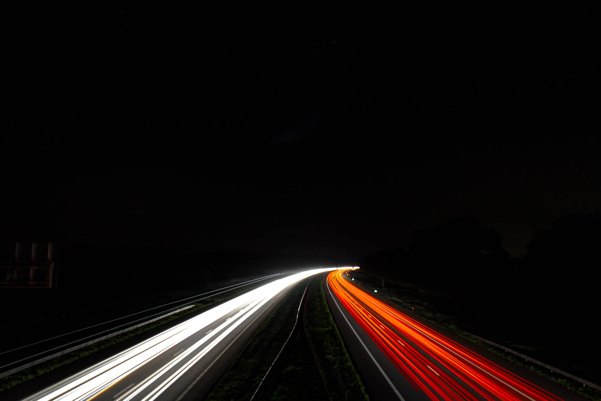 星空下帶有車燈光軌的夜間高速公路