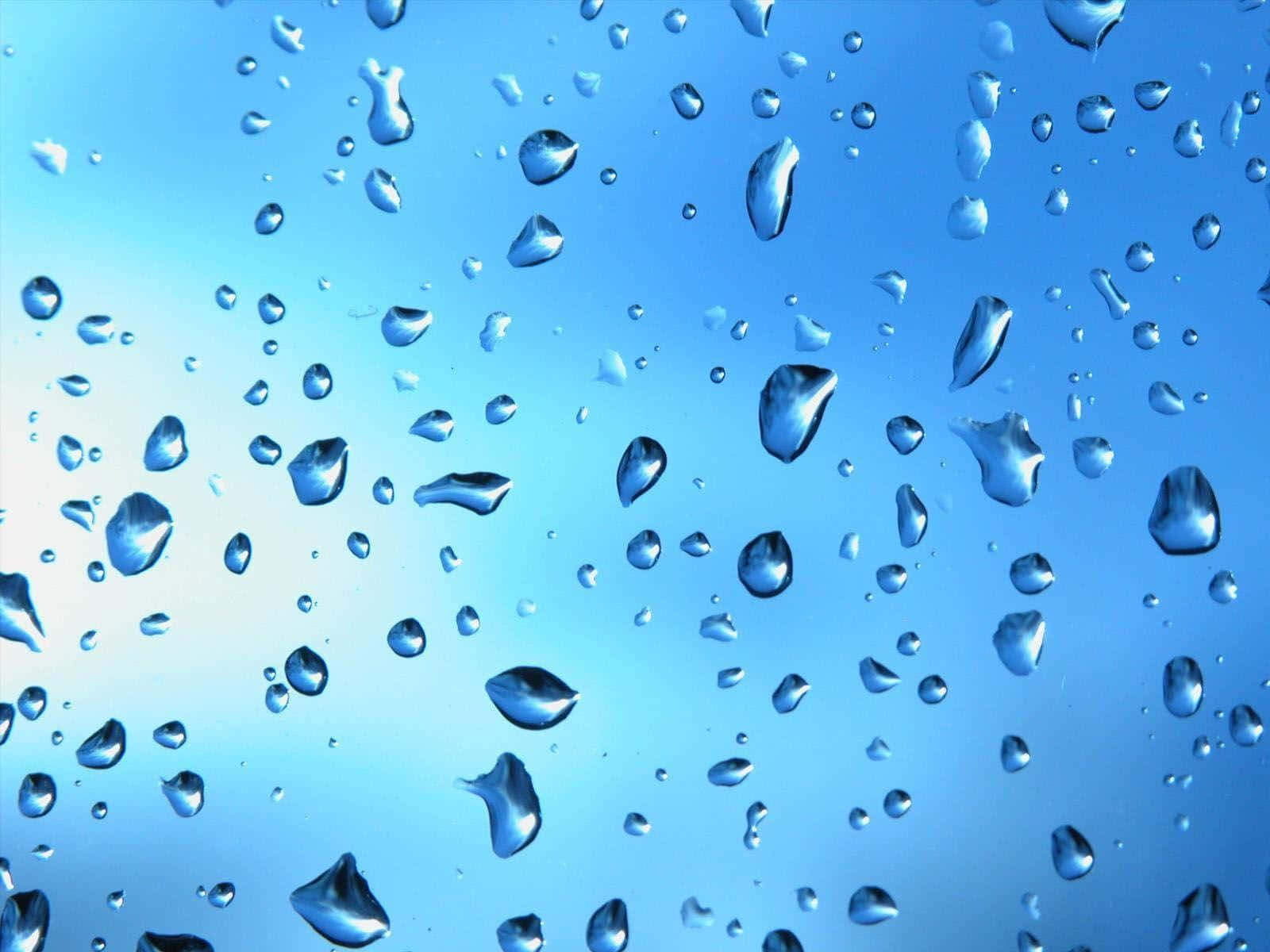 玻璃上的雨滴，帶有藍天反射