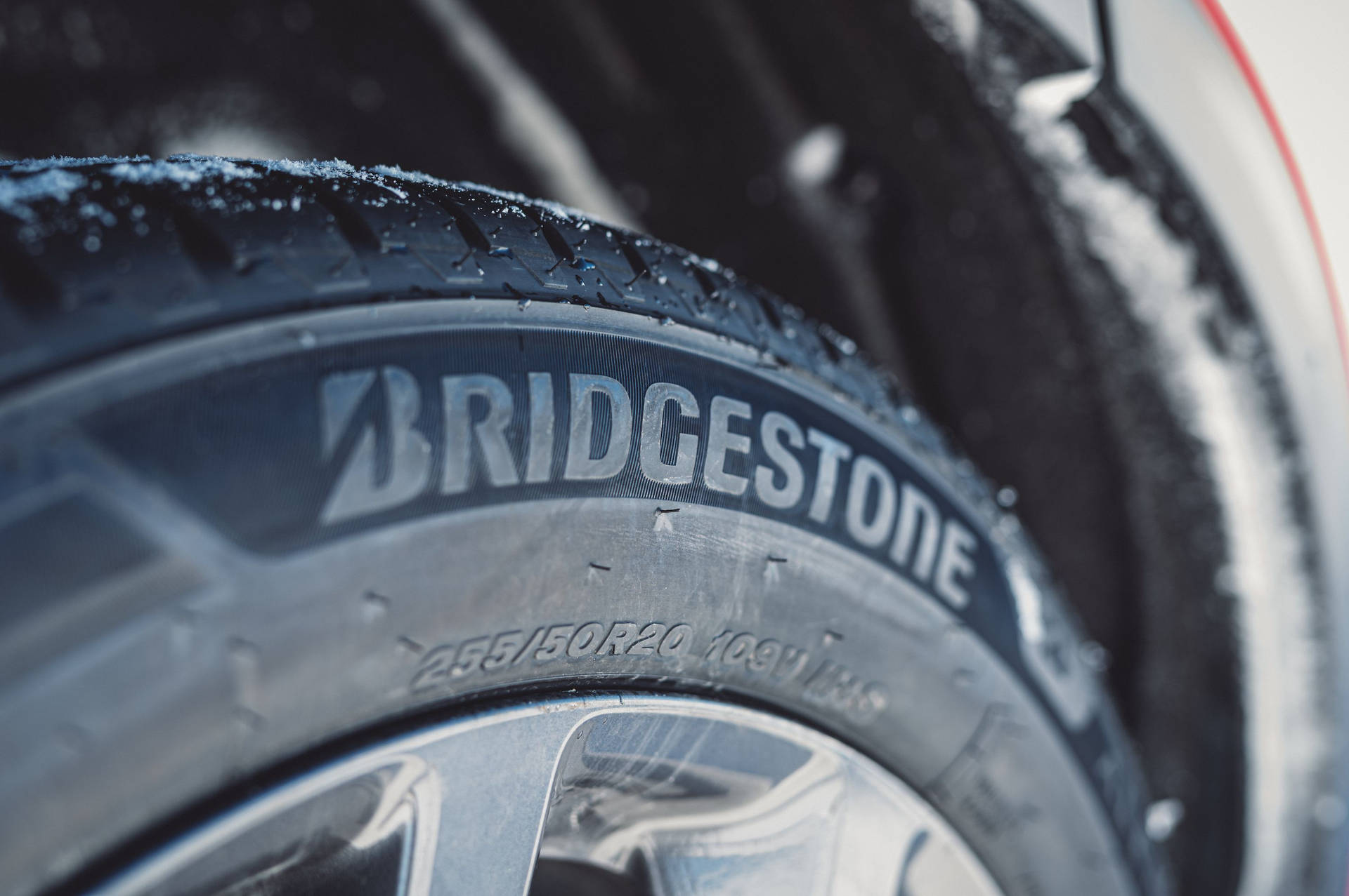 帶有 Bridgestone 品牌標誌的積雪汽車輪胎特寫。