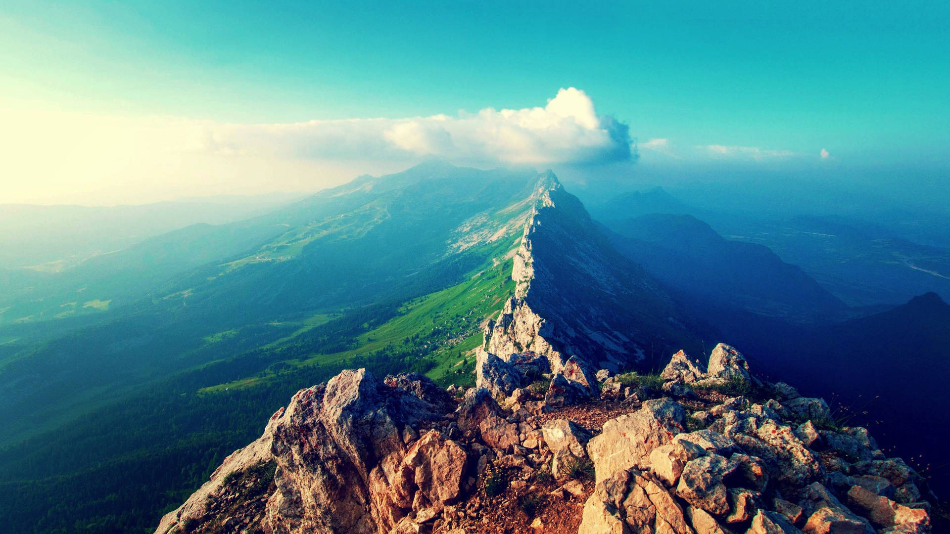 日落時分，岩石山峰俯瞰綠色山谷。