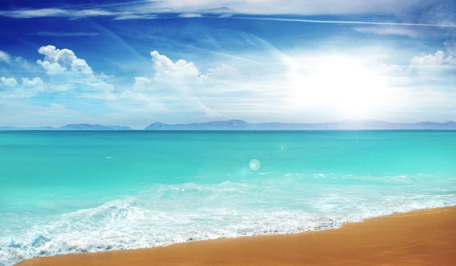 晴朗日子的壯麗海灘風景 壁紙 — 陽光在碧綠色的海浪上閃爍，拍打著金色的沙灘，天空湛藍，白雲朵朵。