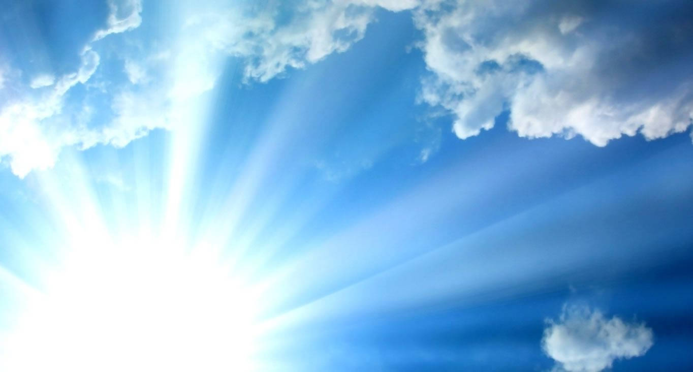 太陽在藍天中穿過白雲明亮地照耀。