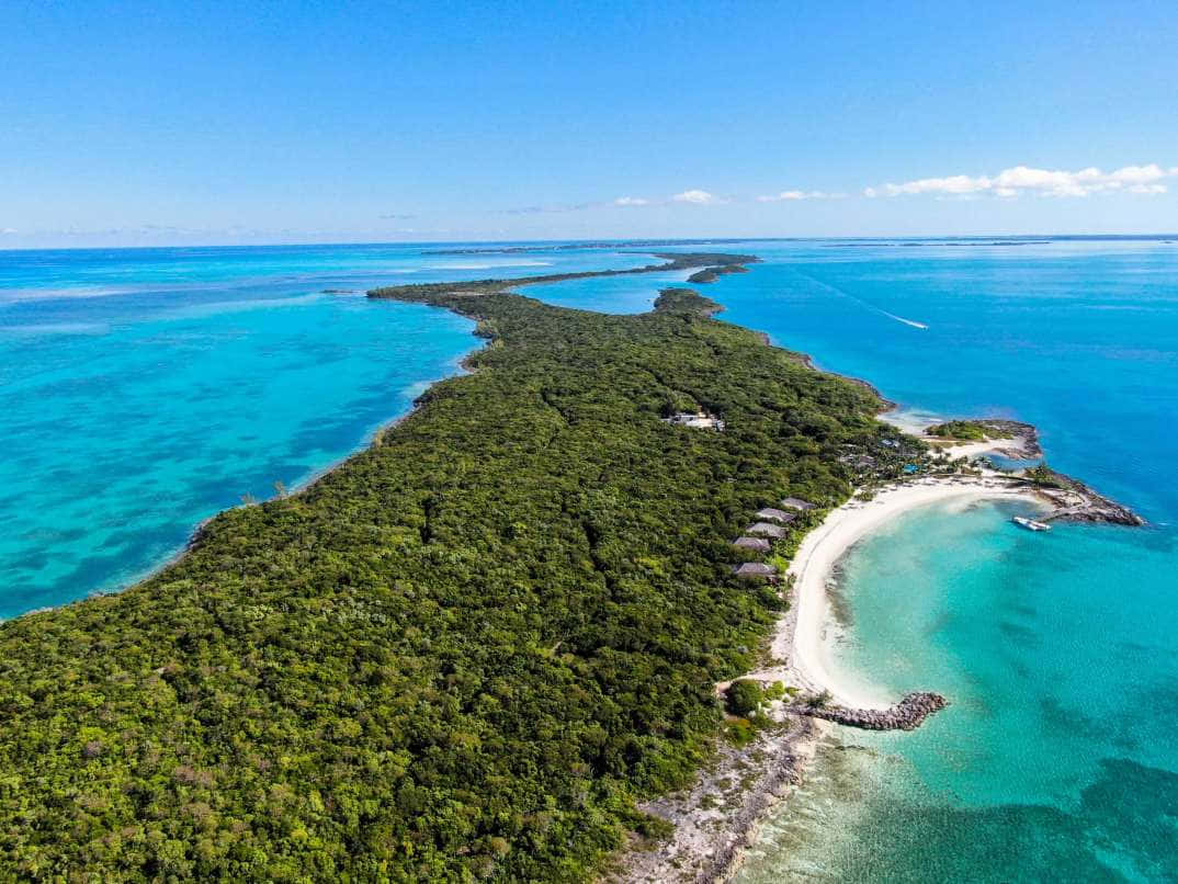 Bahamas Island 桌布 壁紙 — 晴朗藍天下，一個鬱鬱蔥蔥的綠色島嶼，擁有白色沙灘和碧綠海水的鳥瞰圖。