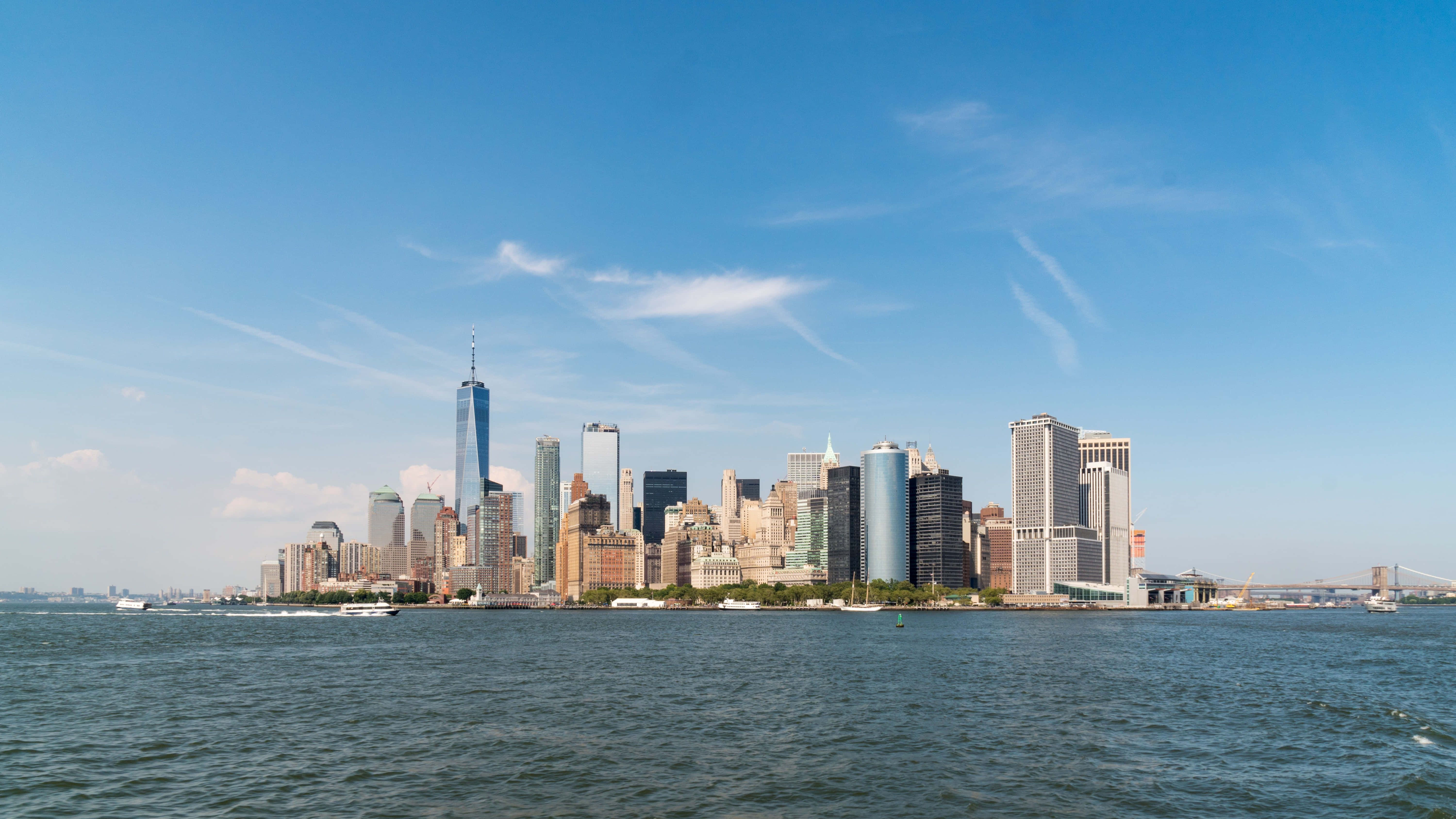 Nyc 桌布 壁紙 — 晴朗藍天下，從水邊拔地而起的摩天大樓構成的紐約市天際線全景。