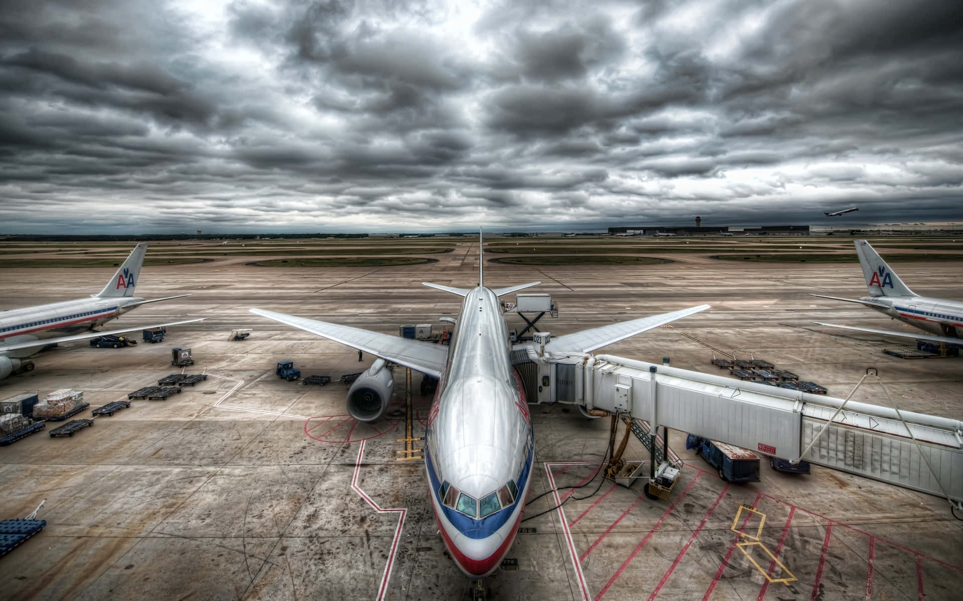 一架大型飛機停在機場登機閘口，天空風雨欲來。