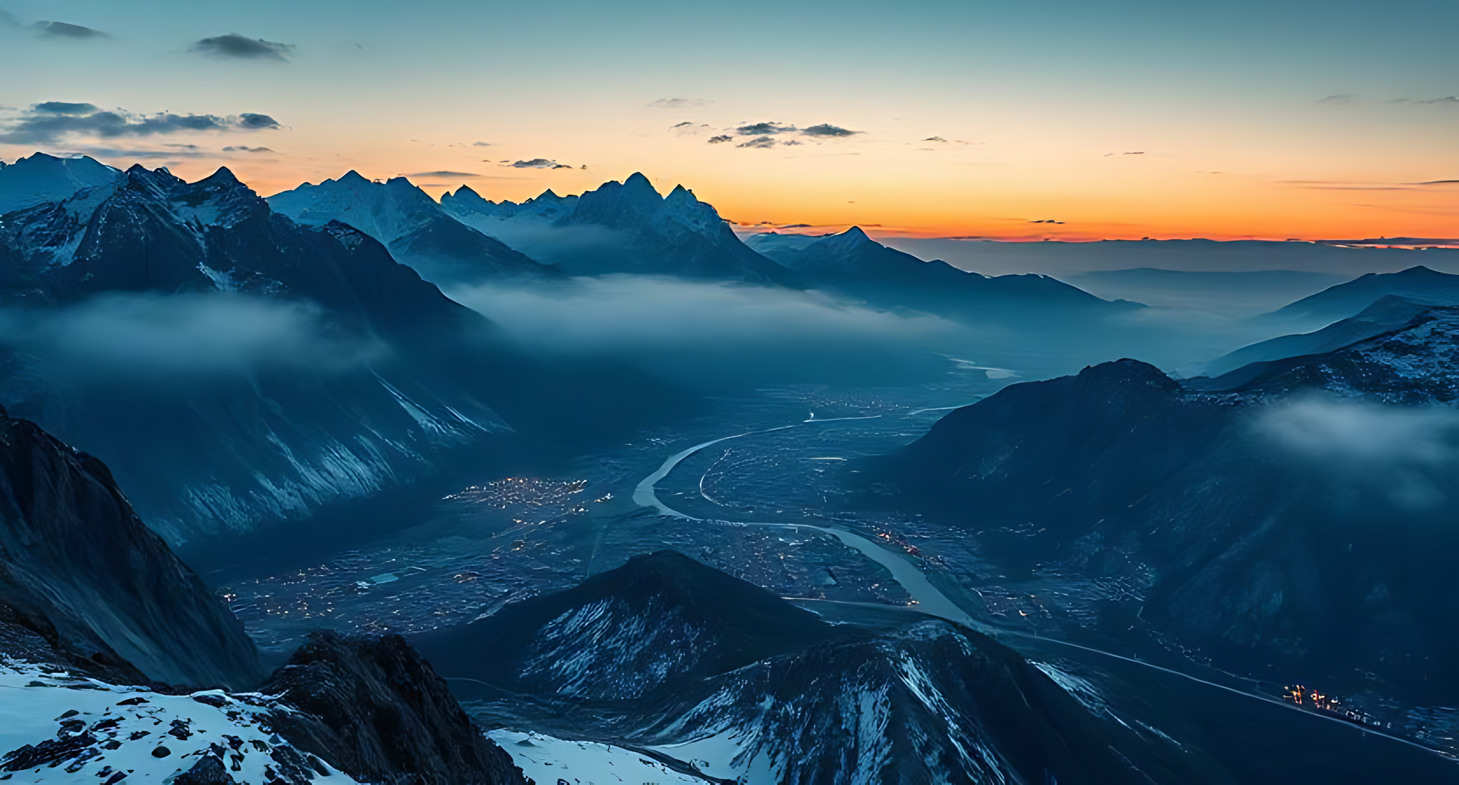 晴空下的雪山群峰 壁紙 — 一個山谷小鎮坐落在積雪的山峰之間，在黃昏時分，城市燈光閃爍，下方有蜿蜒的河流。