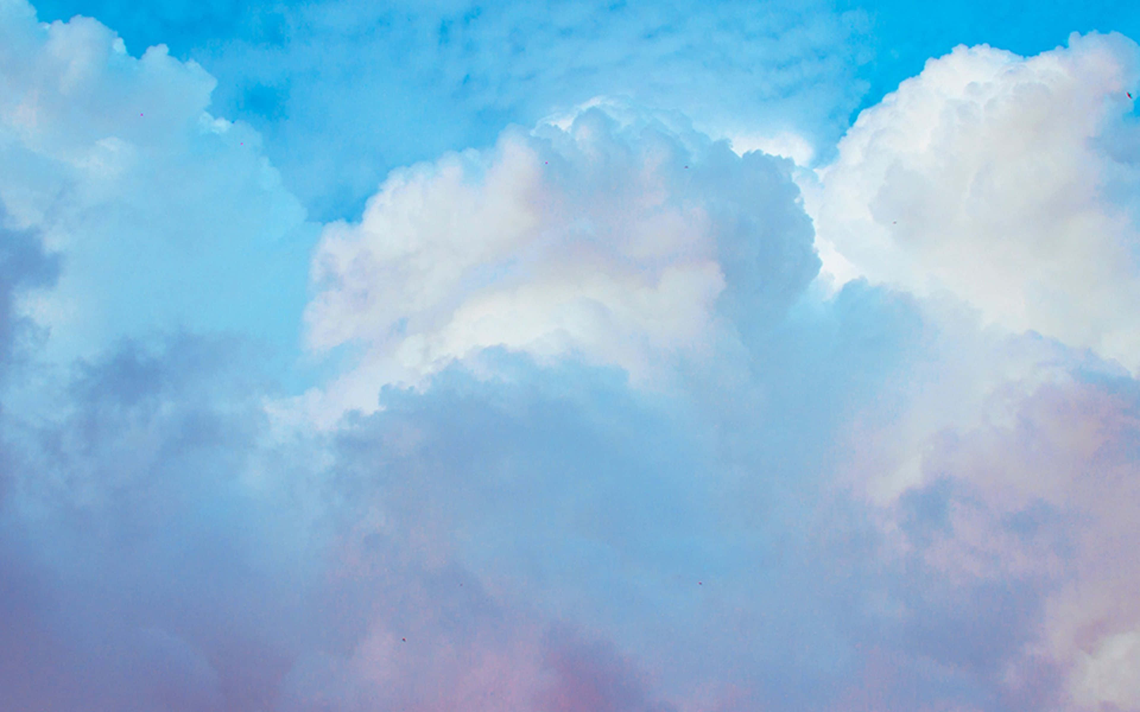 晴空萬里，雲朵悠然 壁紙 — 廣闊的天空中充滿了柔軟如棉的雲朵，帶有粉彩粉紅和藍色調，在清澈的蔚藍蒼穹下。