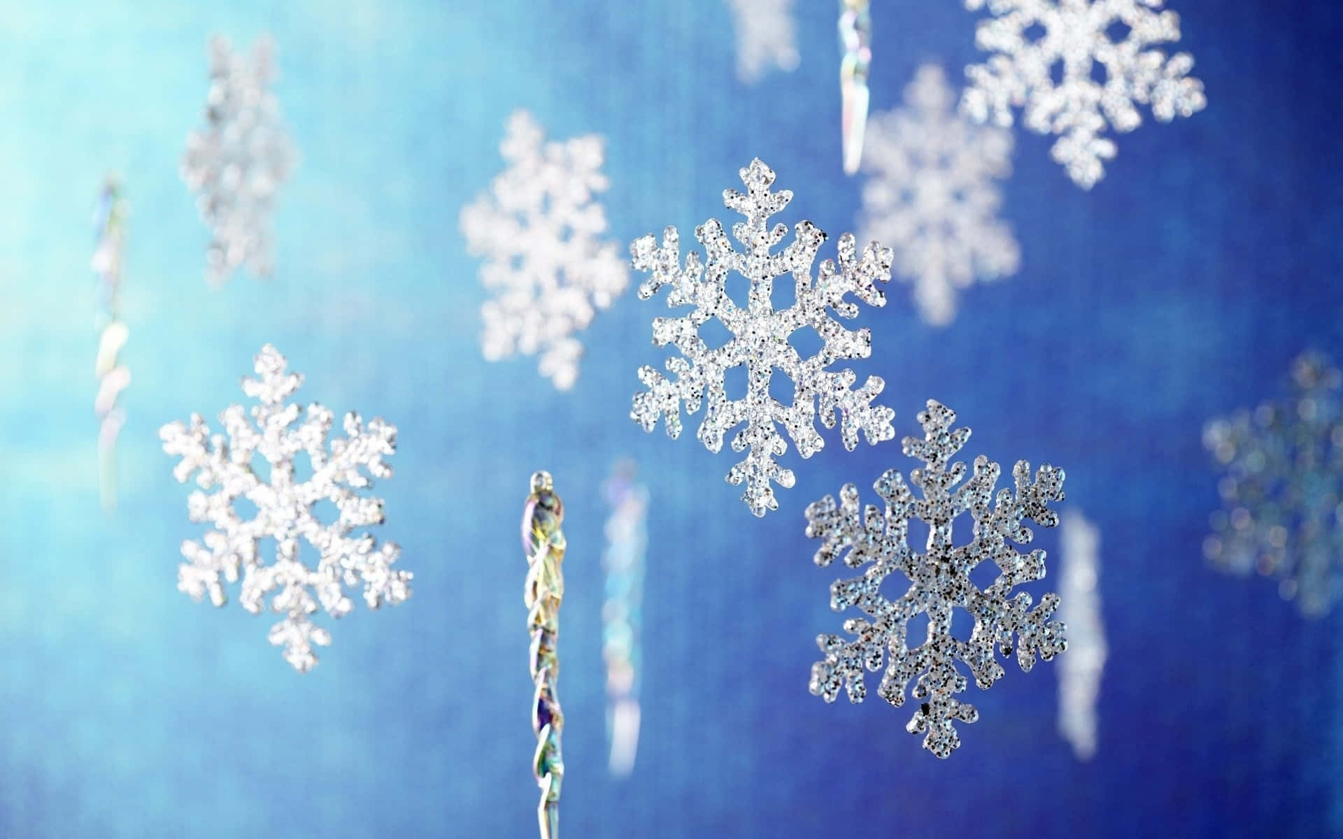 銀色雪花裝飾品懸掛在藍色背景上