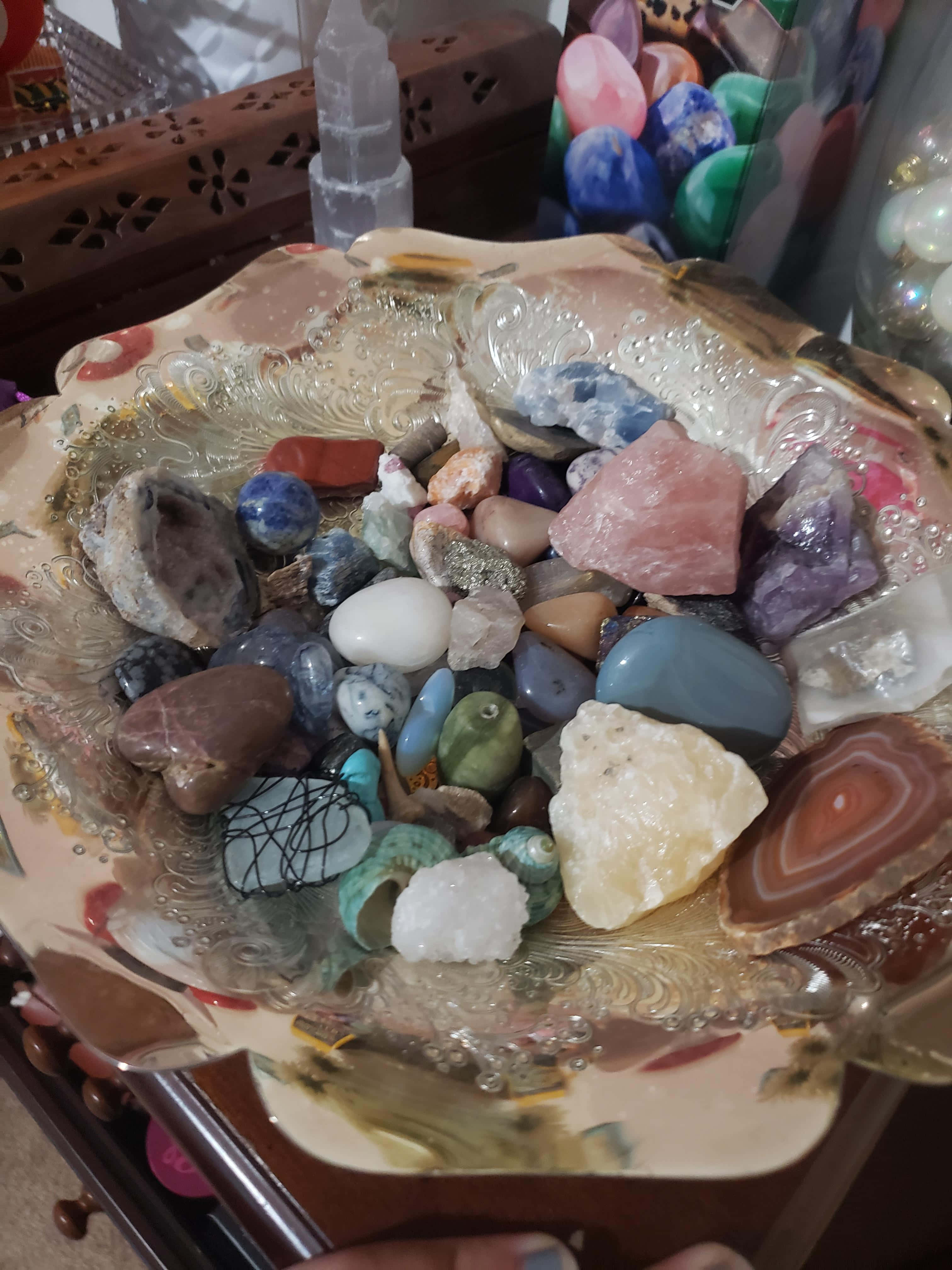 晶體聯展的璀璨呈現 壁紙 — 一個裝飾碗在溫暖的室內燈光下盛載著色彩繽紛的拋光寶石和水晶。