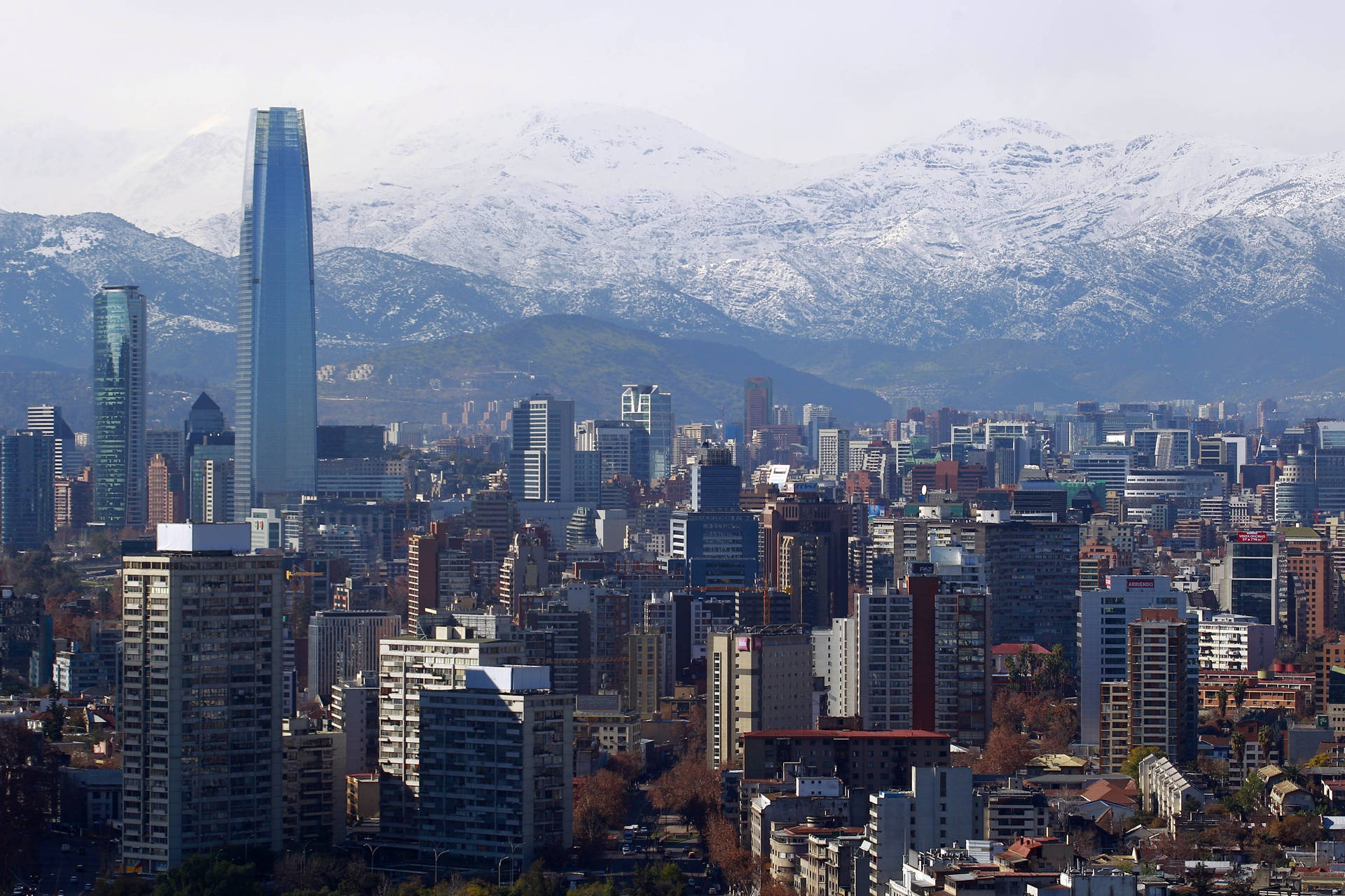 現代城市，高樓大廈和白雪覆蓋的山脈作為背景。