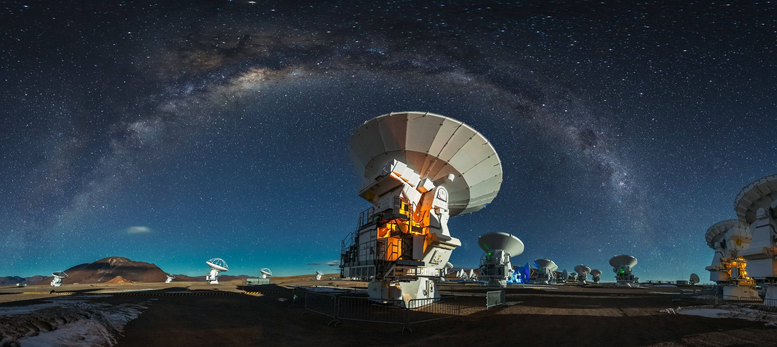 智利阿塔卡馬沙漠宇宙觀測站 壁紙 — 在繁星點點的夜空下，銀河拱掛頭頂的電波望遠鏡全景視圖。