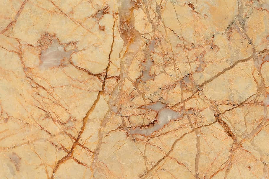 Brown Marble 桌布 壁紙 — 暖色米色大理石特寫，帶有複雜的金棕色紋理和細微的灰色斑塊。