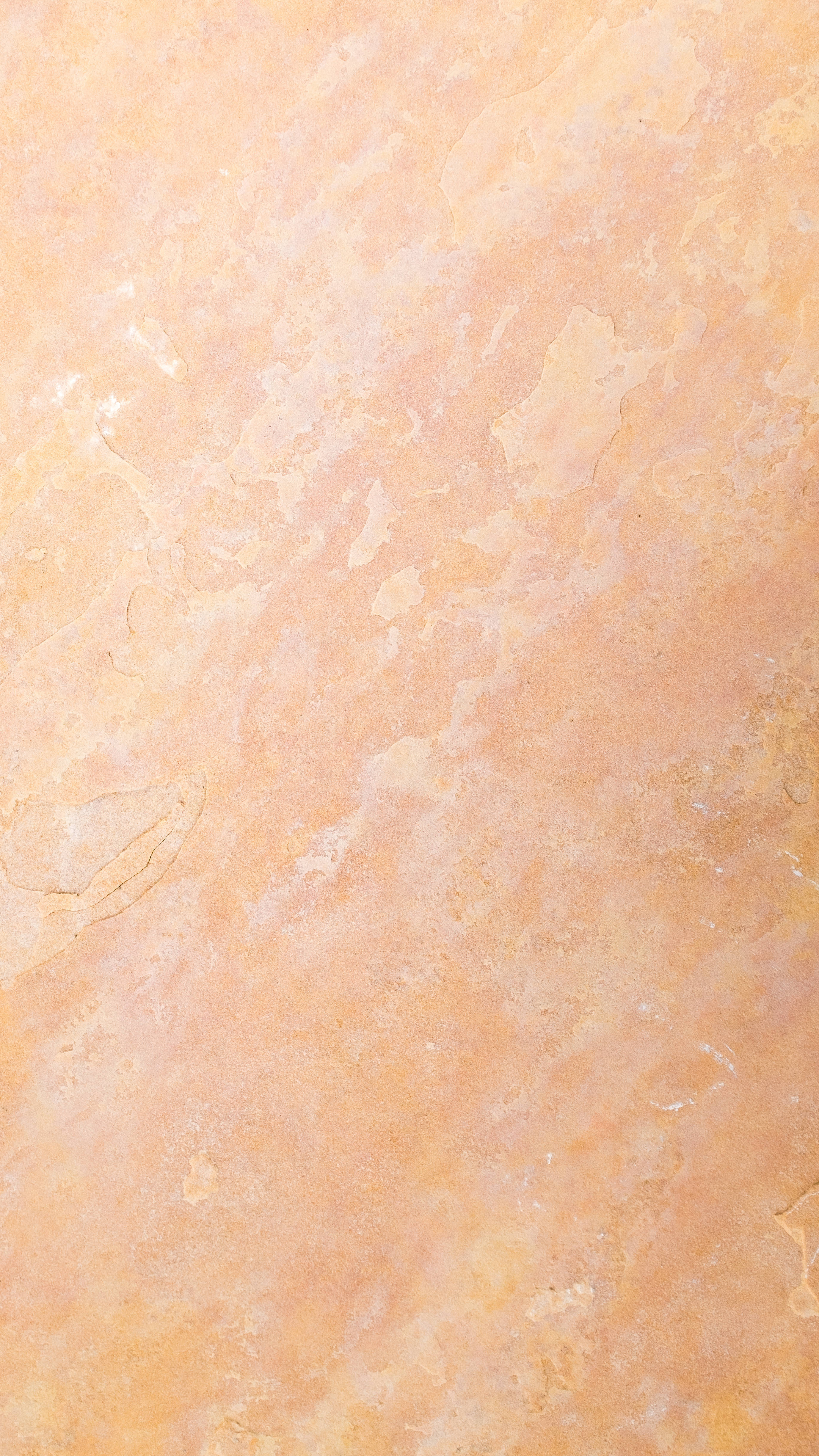 Beige Minimalist 桌布 壁紙 — 暖色調蜜桃色和奶油色紋理牆壁的特寫，帶有細微裂縫和不均勻表面。