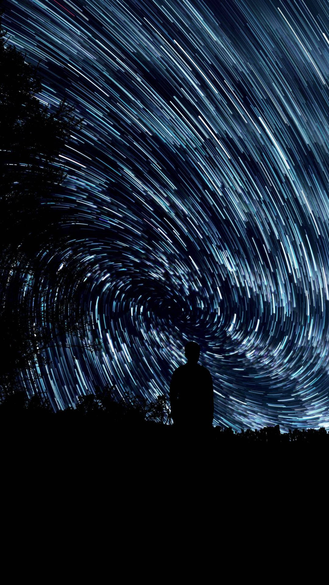 暗夜旋轉星空 壁紙 — 一個孤獨的身影站在夜空中盤旋的藍色星軌漩渦之下。