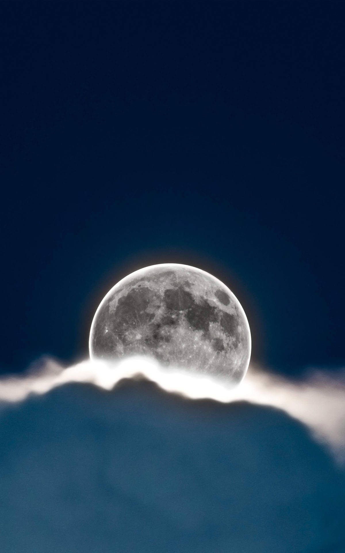 暗夜月雲 壁紙 — 一輪明亮的滿月在柔軟的雲層上升起，背景是深靛藍色的夜空。