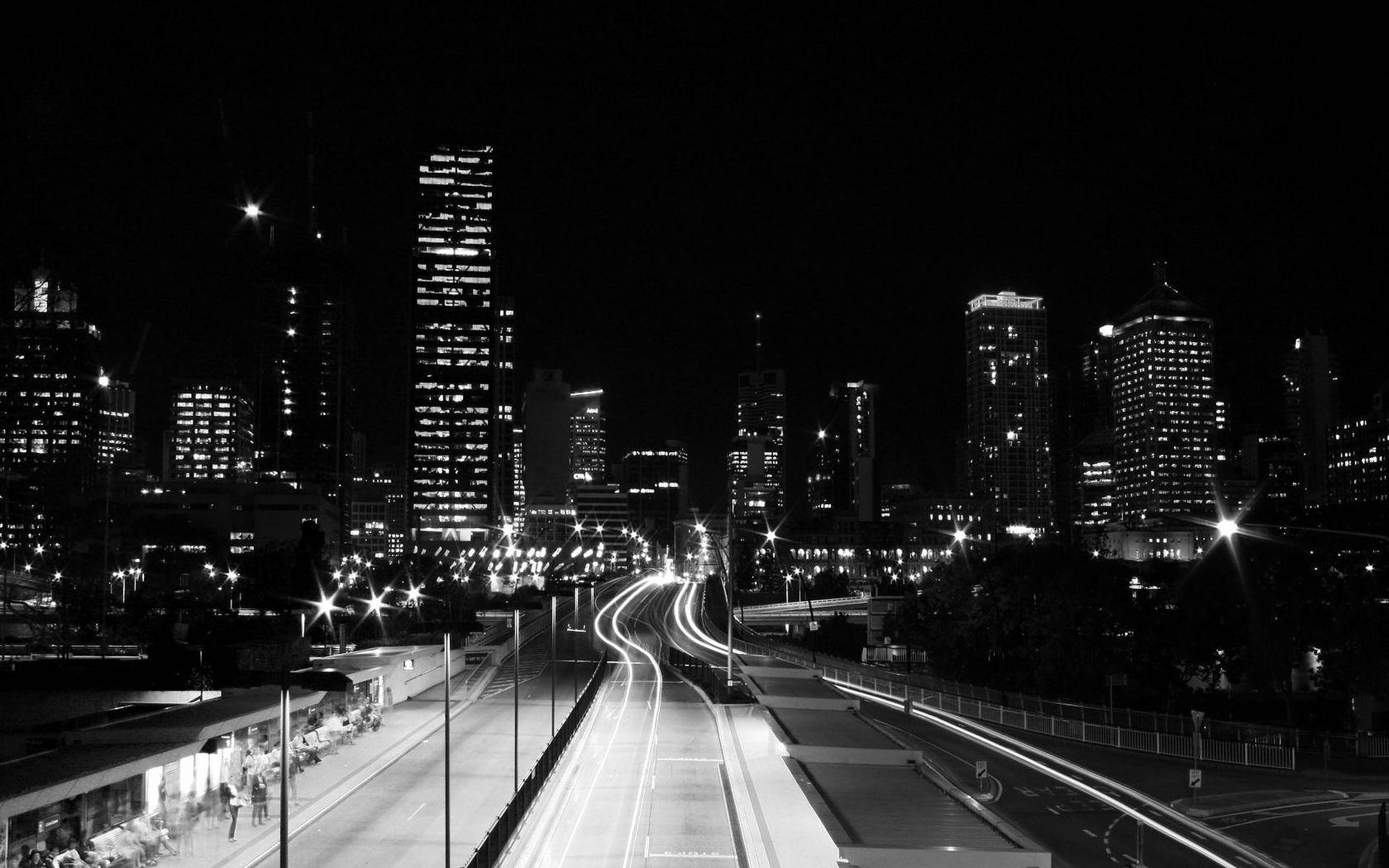 夜晚城市景觀，高速公路上的汽車燈光軌跡和亮燈的摩天大樓。 — 暗夜城市 壁紙