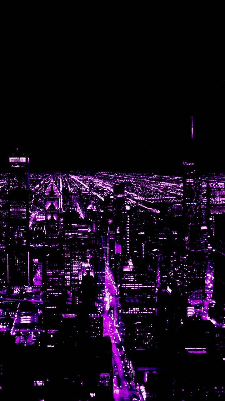 紫色霓虹燈從上方照亮了夜晚廣闊的城市景觀。
