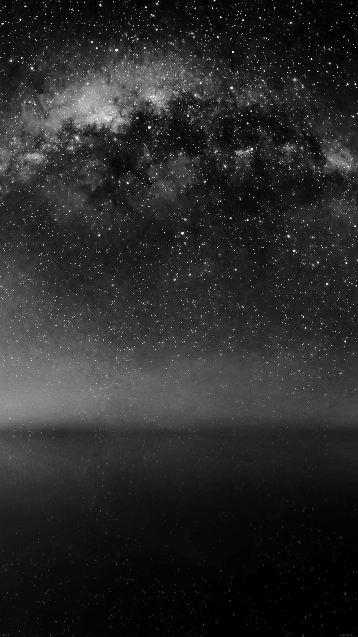 暗色手機灰階夜空 壁紙 — 在繁星點點的夜空下，銀河系在霧濛濛的地平線上拱起，令人嘆為觀止的黑白景觀。
