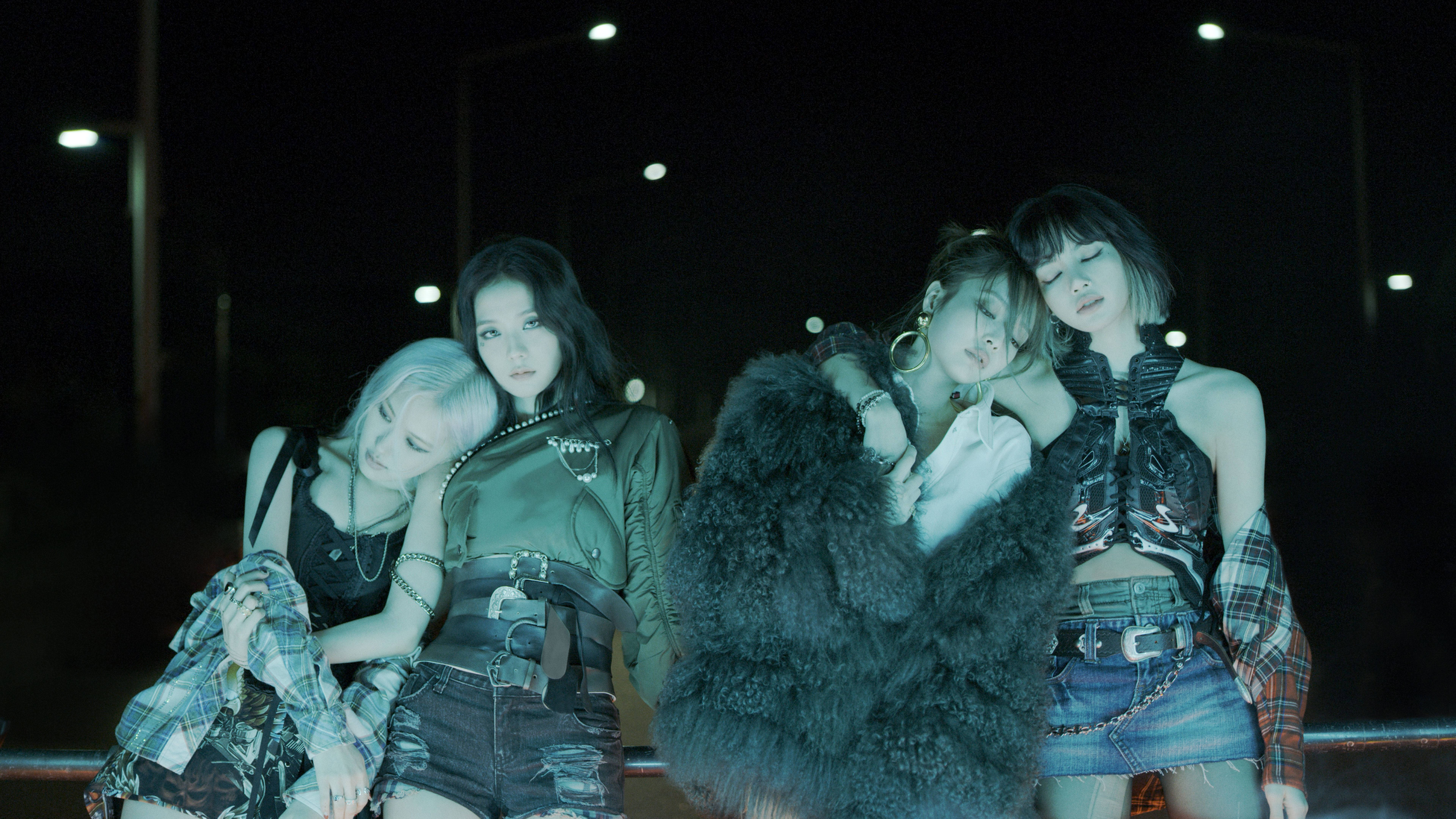 暗色系服裝Blackpink桌面壁紙 壁紙 — 四位時尚女性在夜晚黑暗的城市街道上，在霓虹燈下親密地擺姿勢。
