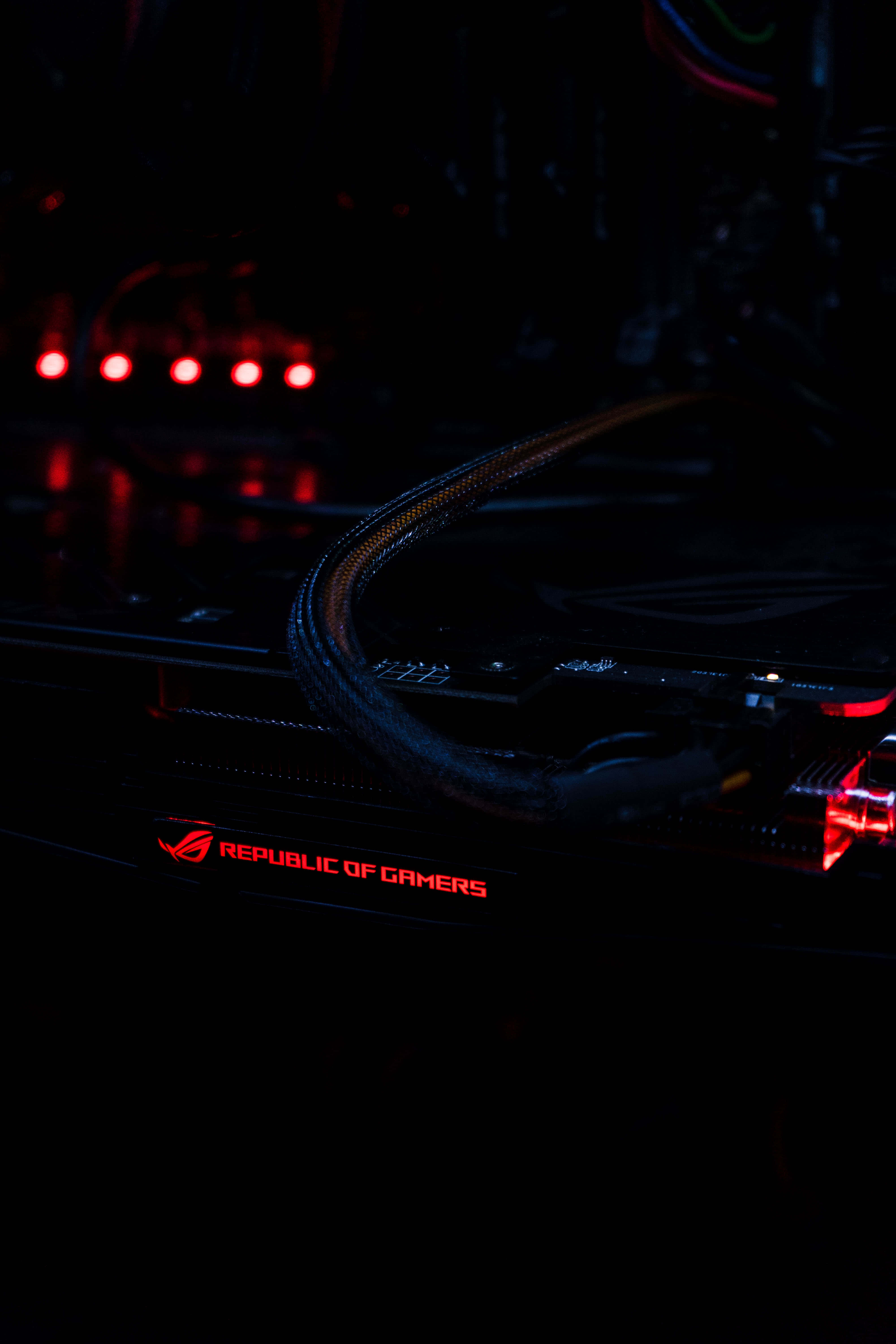 Gamer 桌布 壁紙 — 暗色遊戲PC的特寫，帶有發光的紅色ROG Republic of Gamers標誌和LED燈。