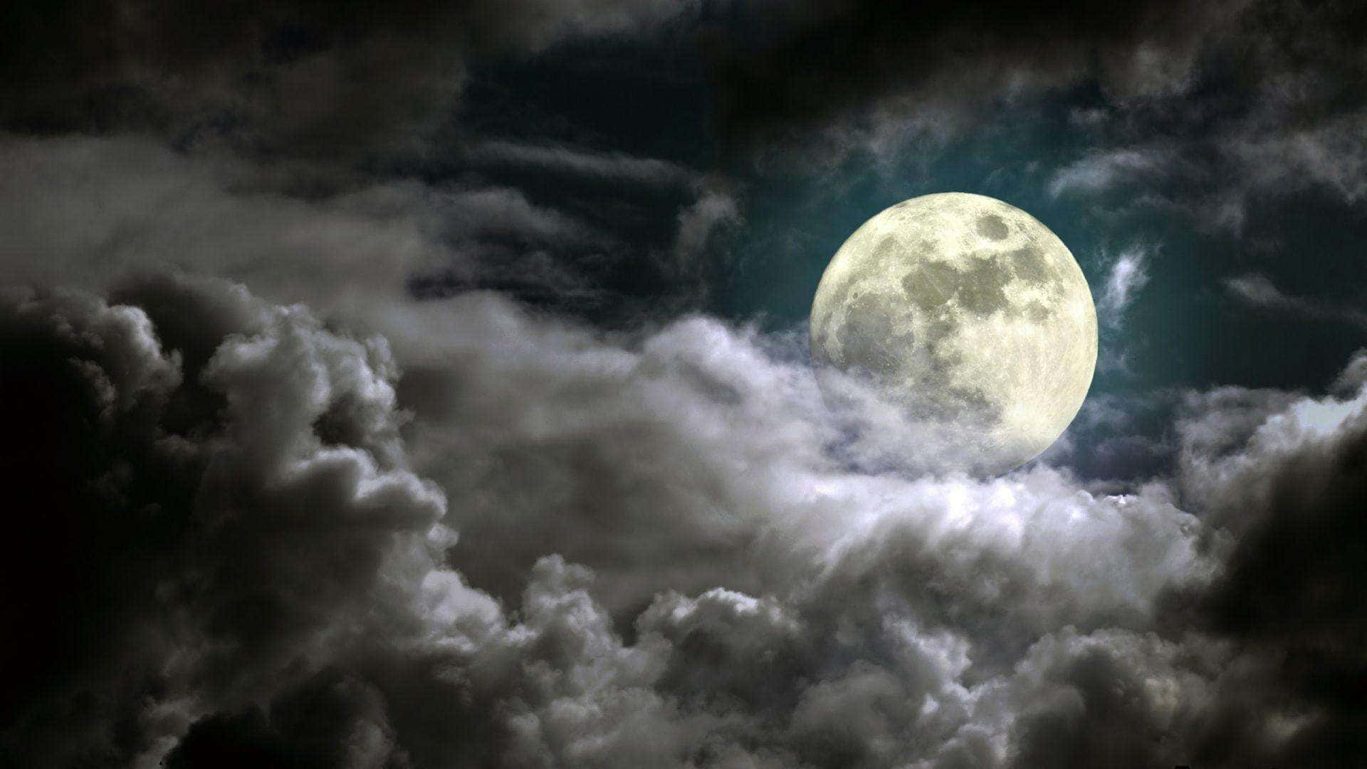 夜晚，一輪明亮的滿月在厚厚的烏雲後發光。