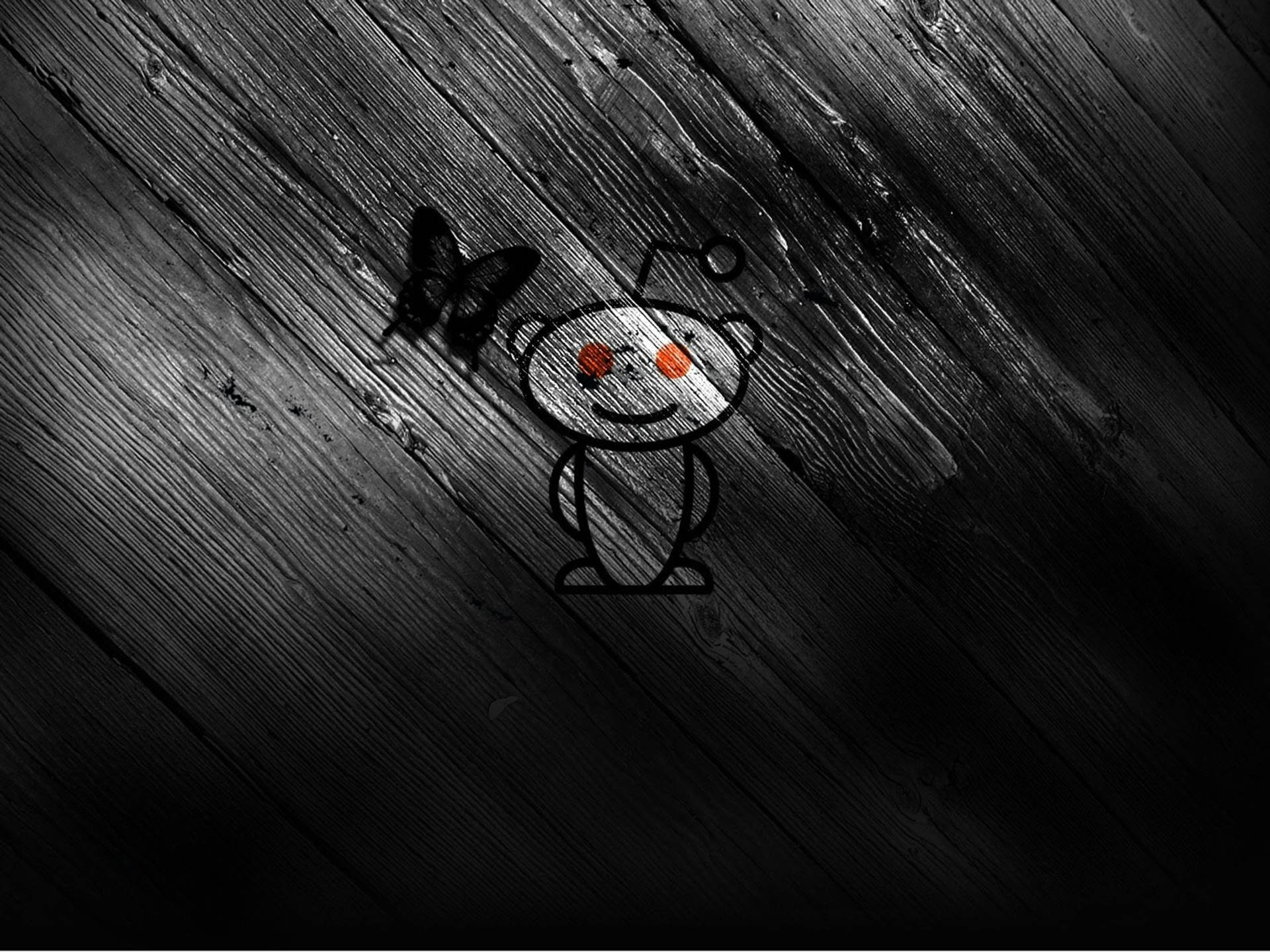 橙色眼睛的 Reddit 外星人，深色木頭，蝴蝶