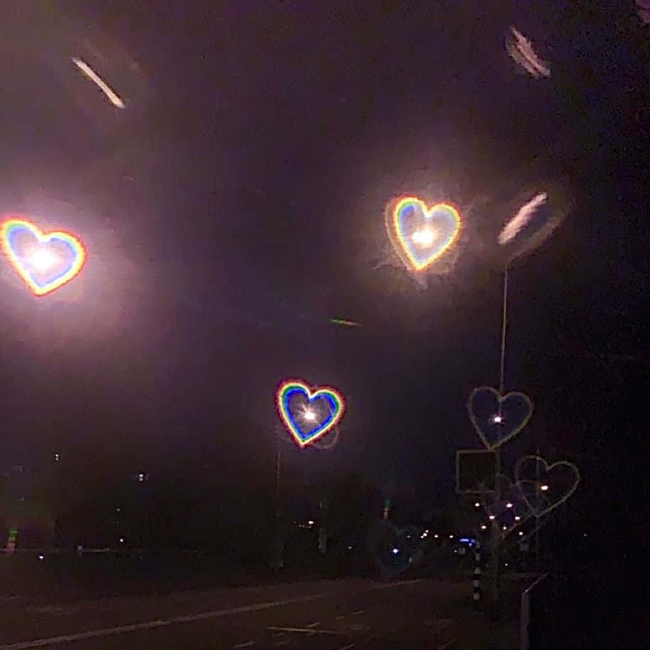 愛心燈光在夜空中發光，街道上方。