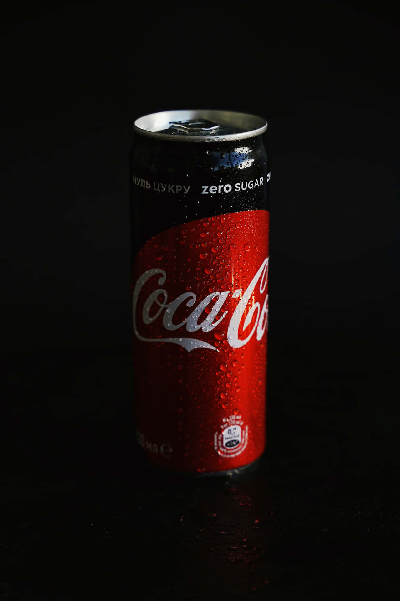 冰凍的Coca-Cola Zero Sugar罐在深色表面上帶有冷凝水珠