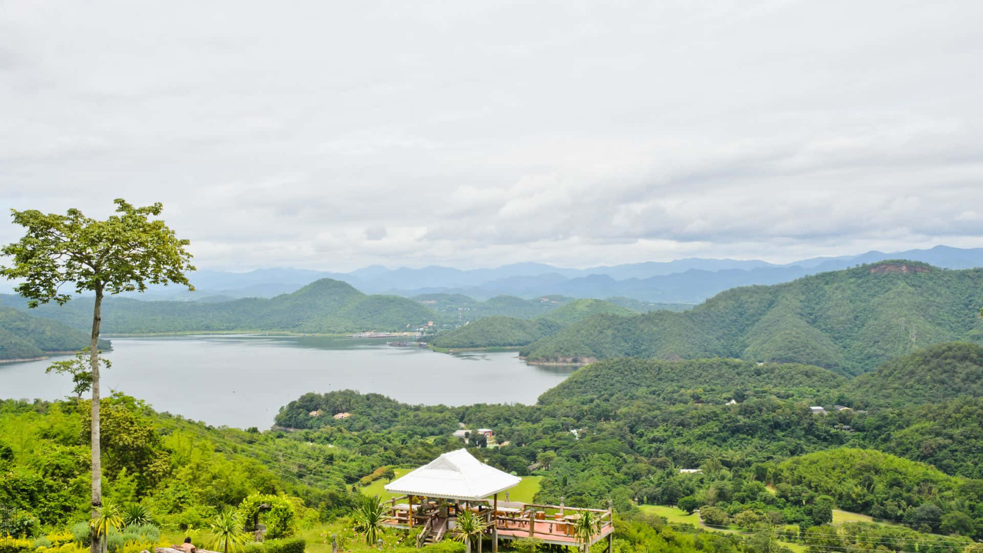 湖泊坐落在青山之間，有一座白色亭子的風景優美的觀景點。
