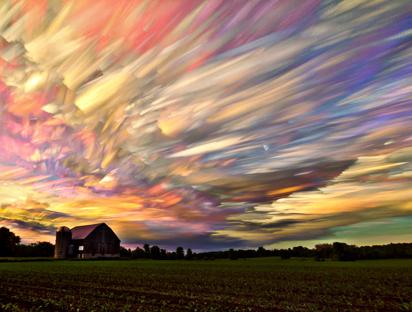 Trippy Sky 桌布 壁紙 — 暮色中，一座穀倉的剪影映襯著火紅橙、粉紅和紫色的條紋天空。