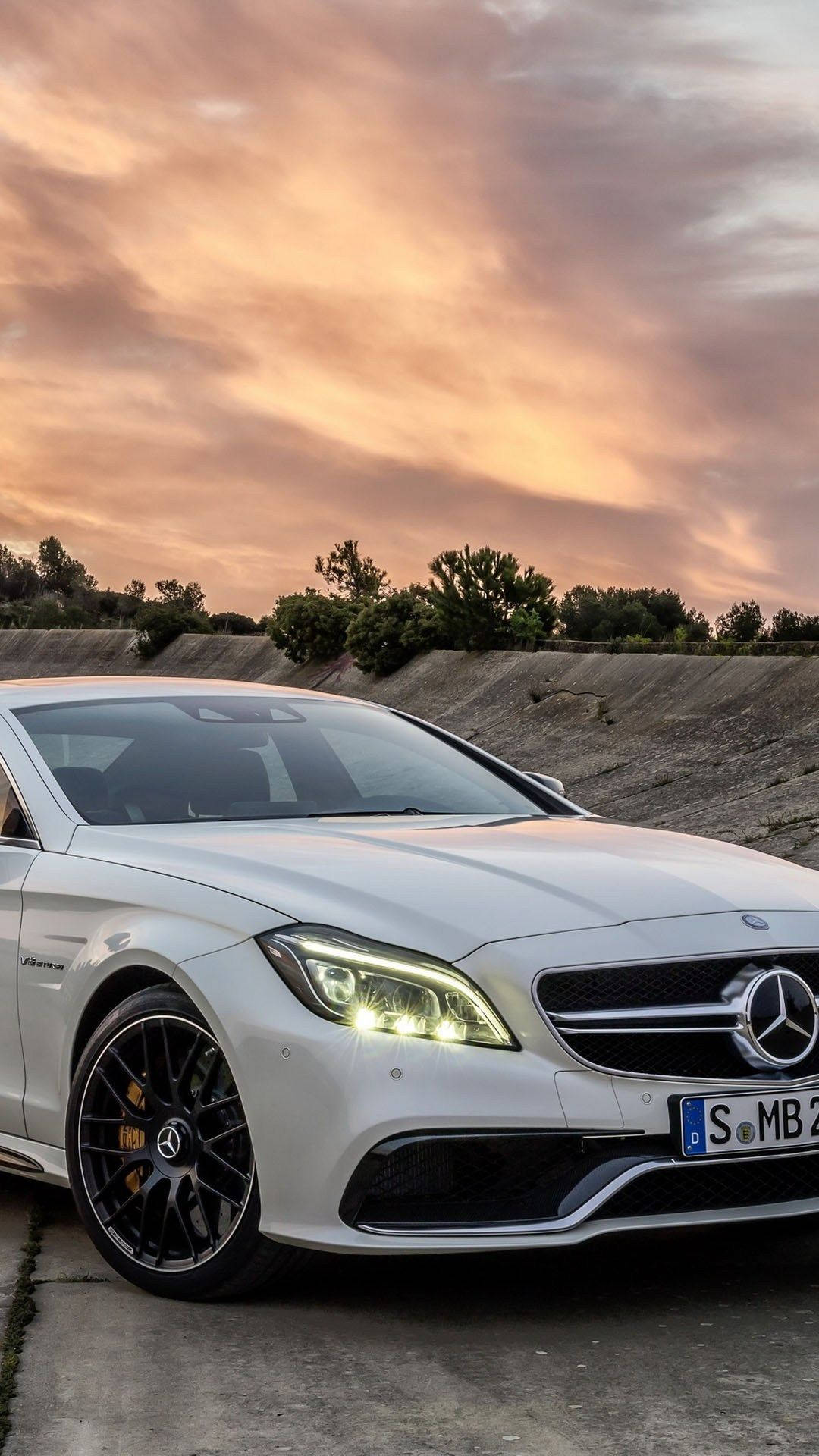 白色 Mercedes-AMG 跑車在日落時停靠在路邊。