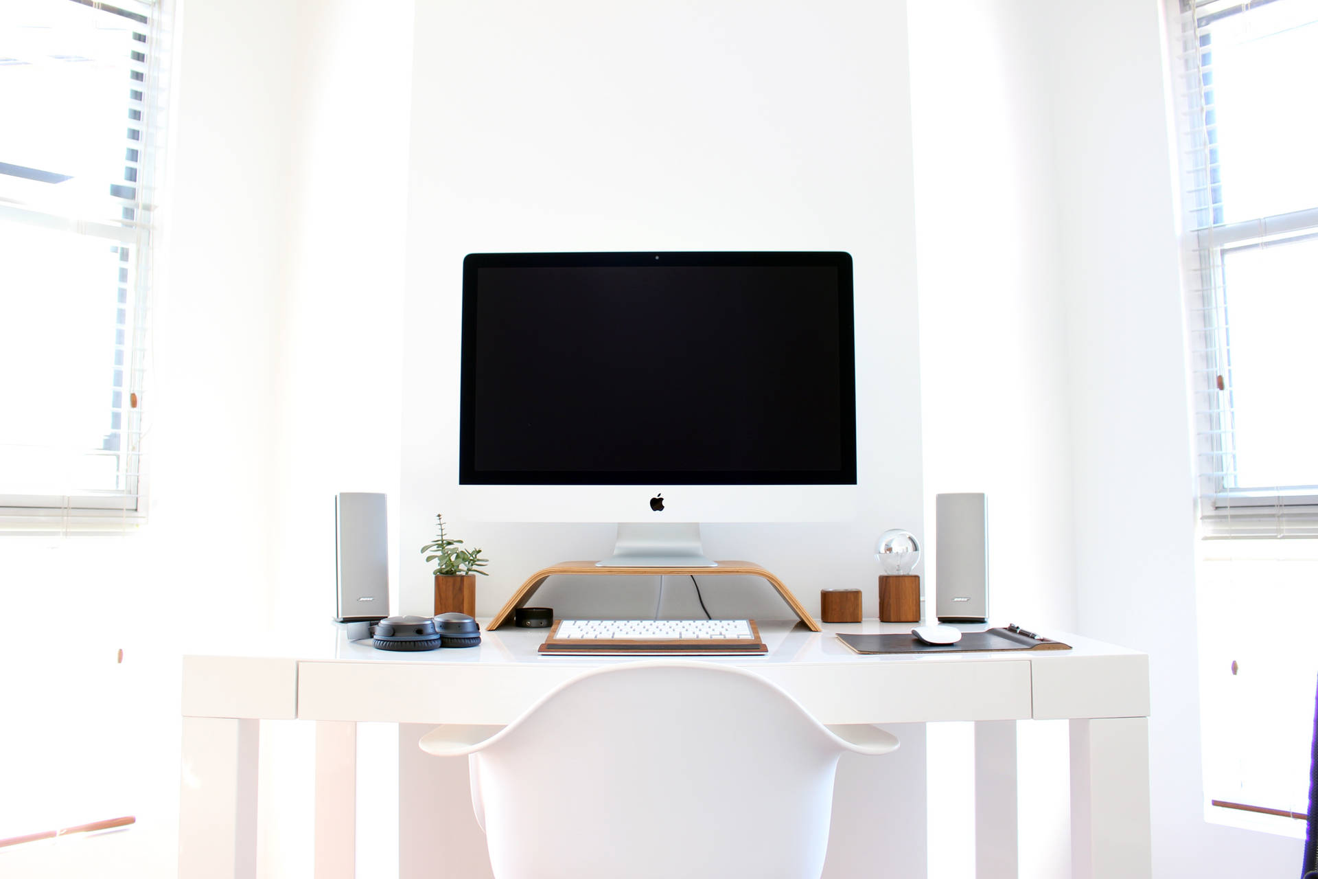 簡約白色家庭辦公室，配備 iMac 和自然光