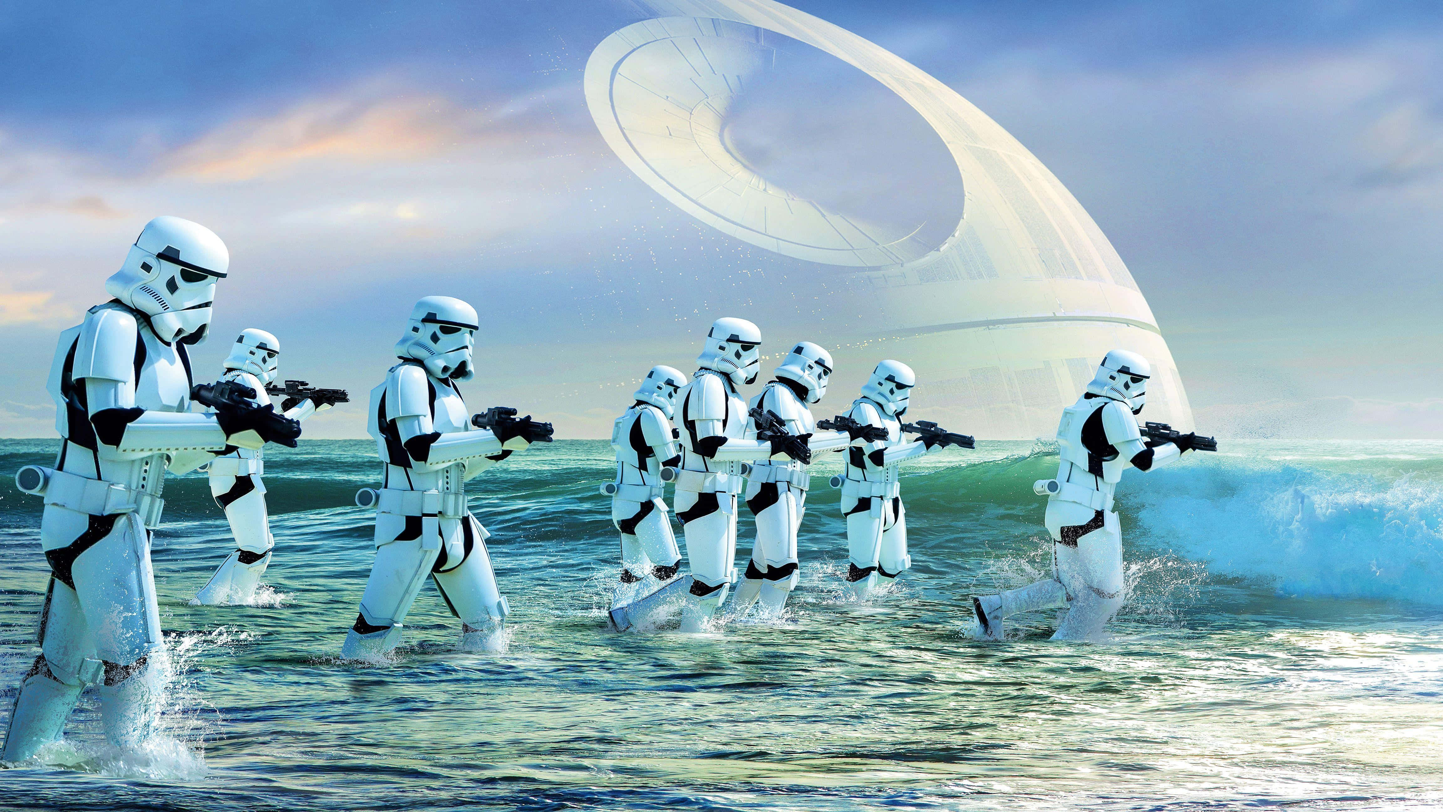 Scarif 桌布 壁紙 — 暴風兵在陰天之下穿過海浪，向一艘巨大的白色太空船行進。