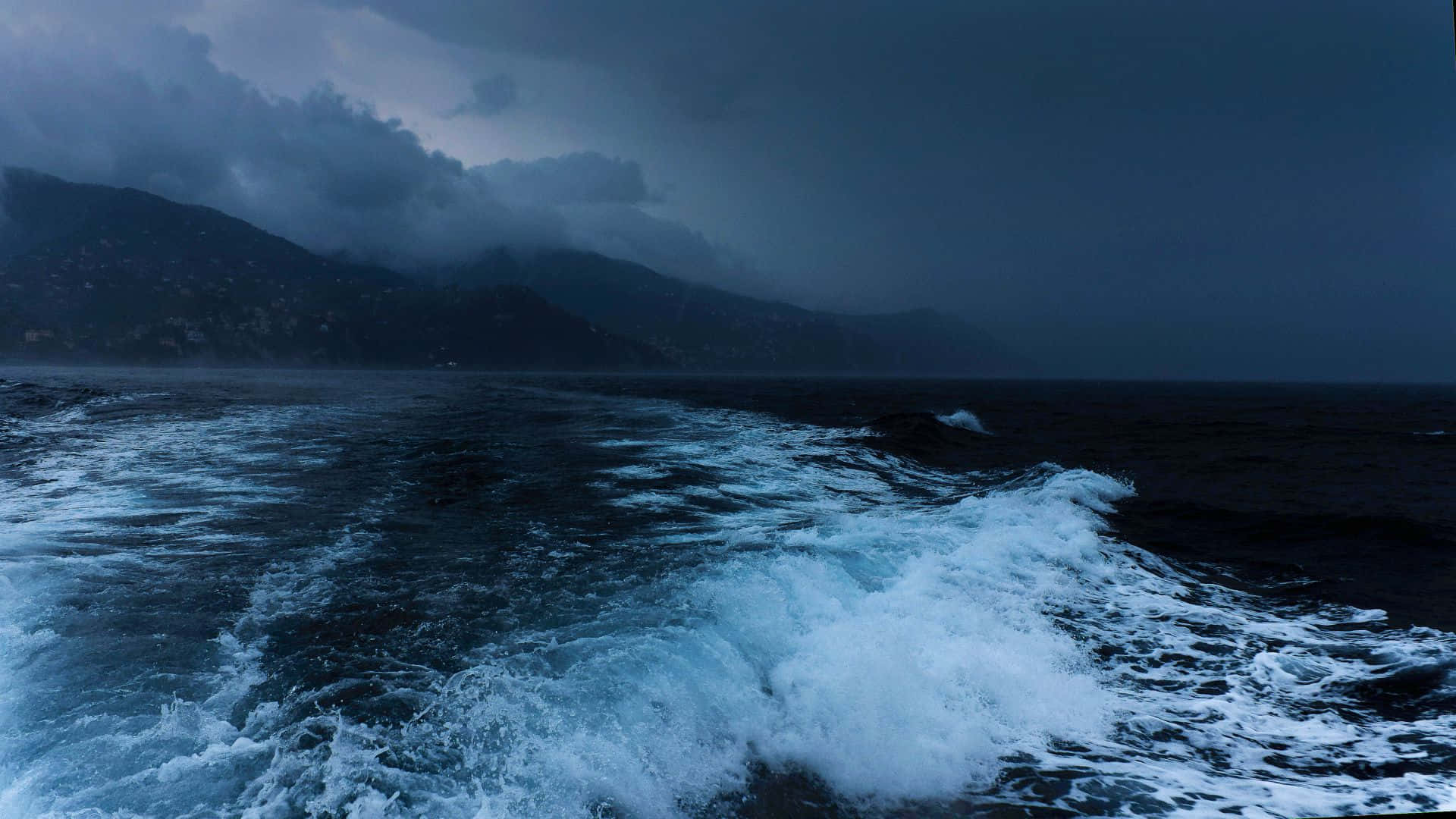 陰暗的暴風雨海洋，白色泡沫拍打著遠山。