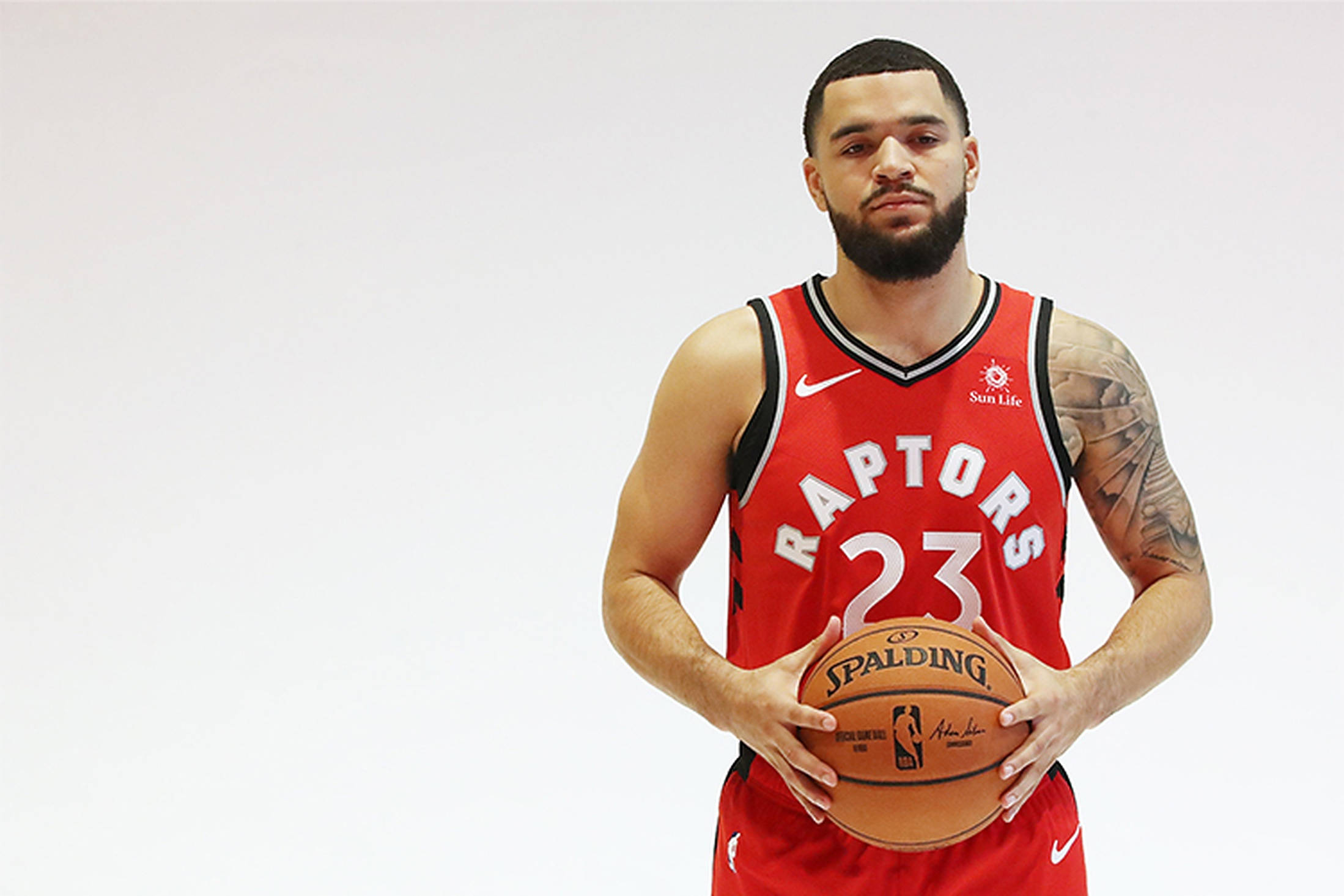 暴龍隊Fred Vanvleet 肖像 壁紙 — 一名身穿紅色Raptors球衣的籃球運動員，在純白色背景前手持Spalding籃球。