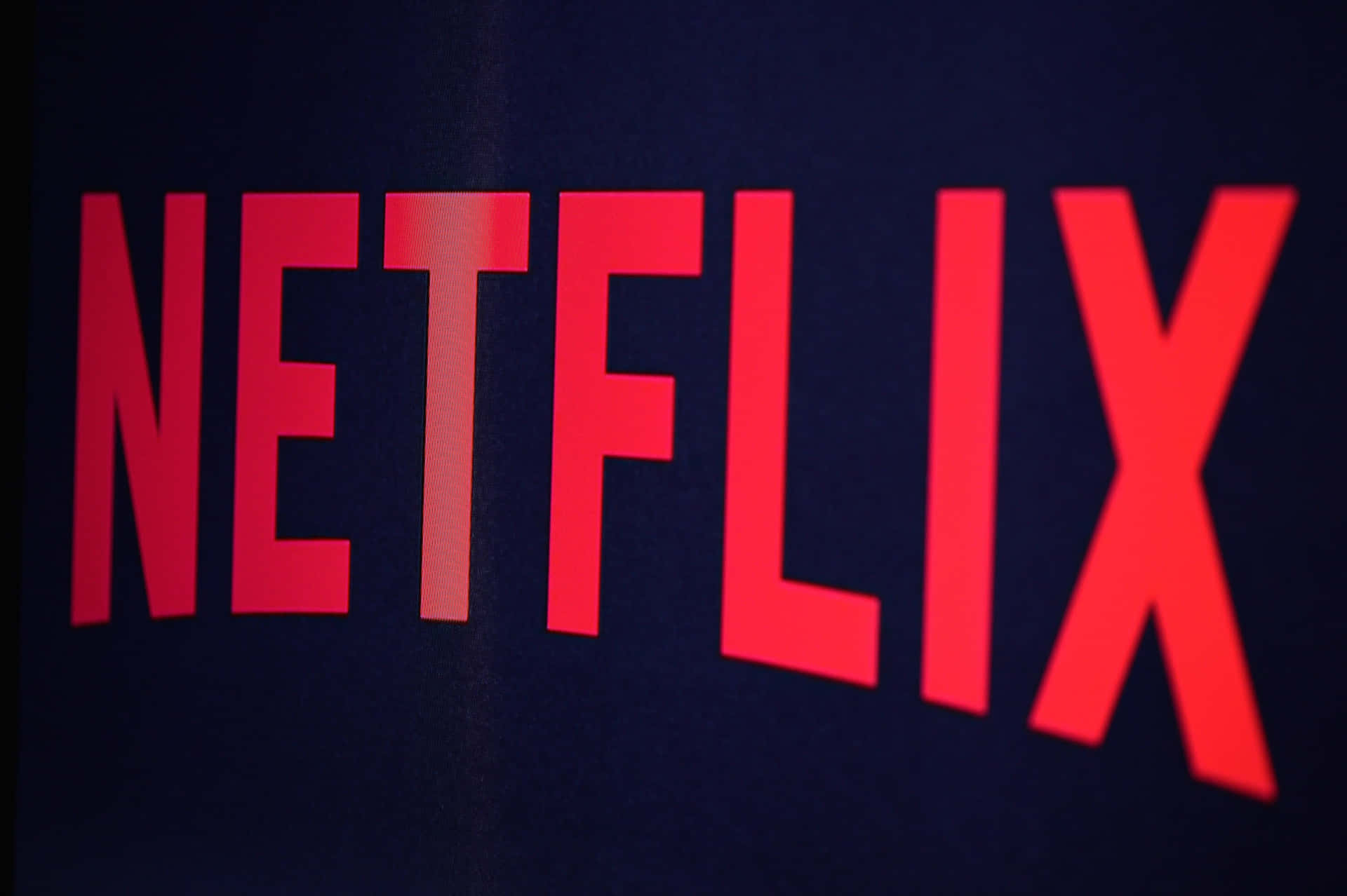 深色背景上柔和光線下的紅色 Netflix 標誌