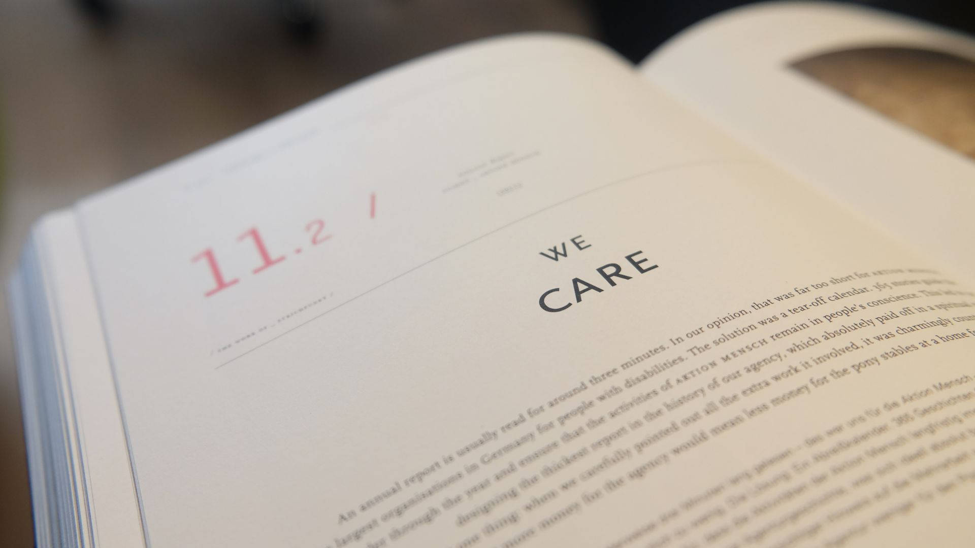 書本頁面特寫，顯示 '11.2' 和 'WE CARE' 文字。