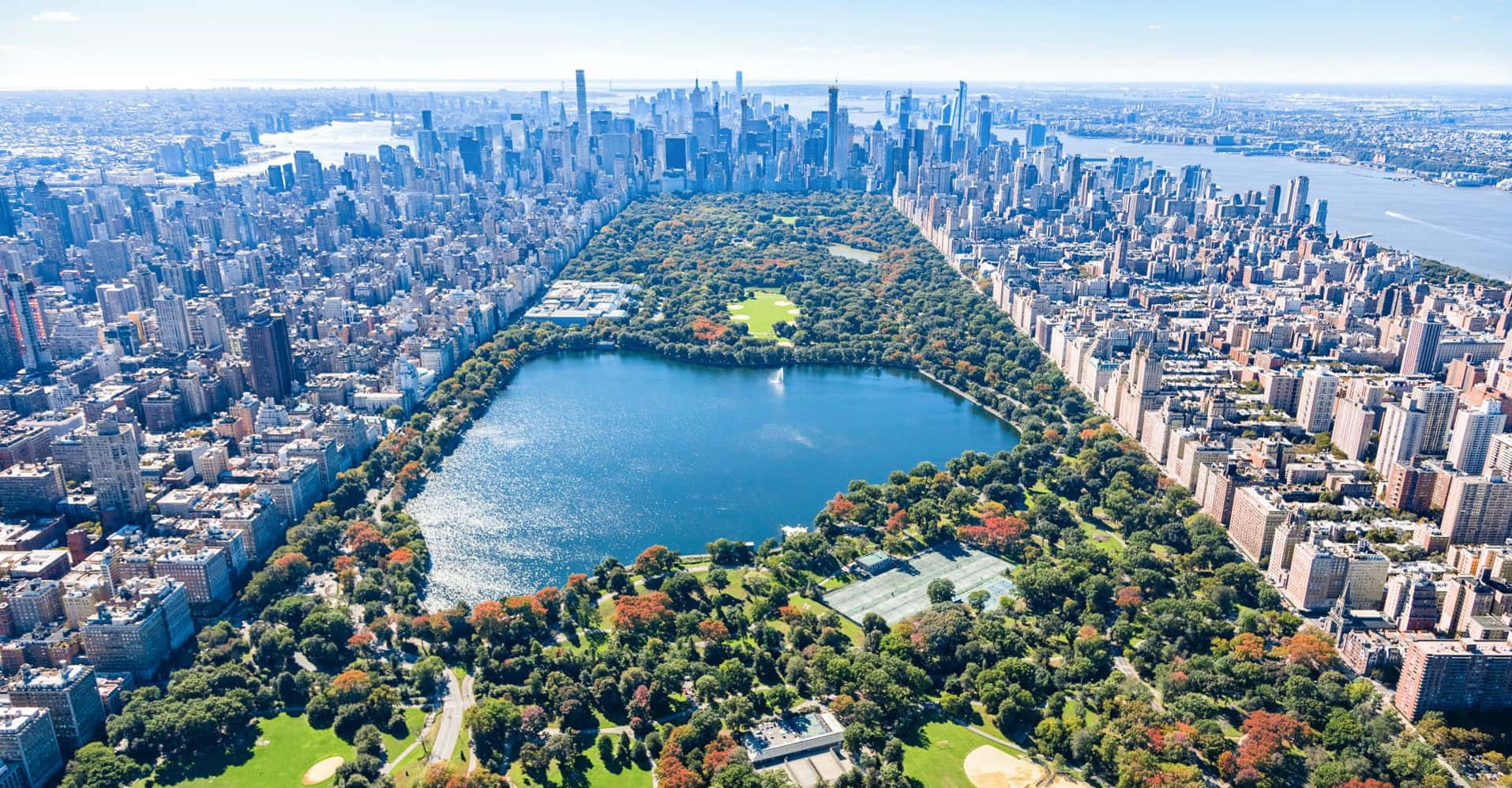在陽光明媚的秋日，中央公園被紐約市的摩天大樓環繞。