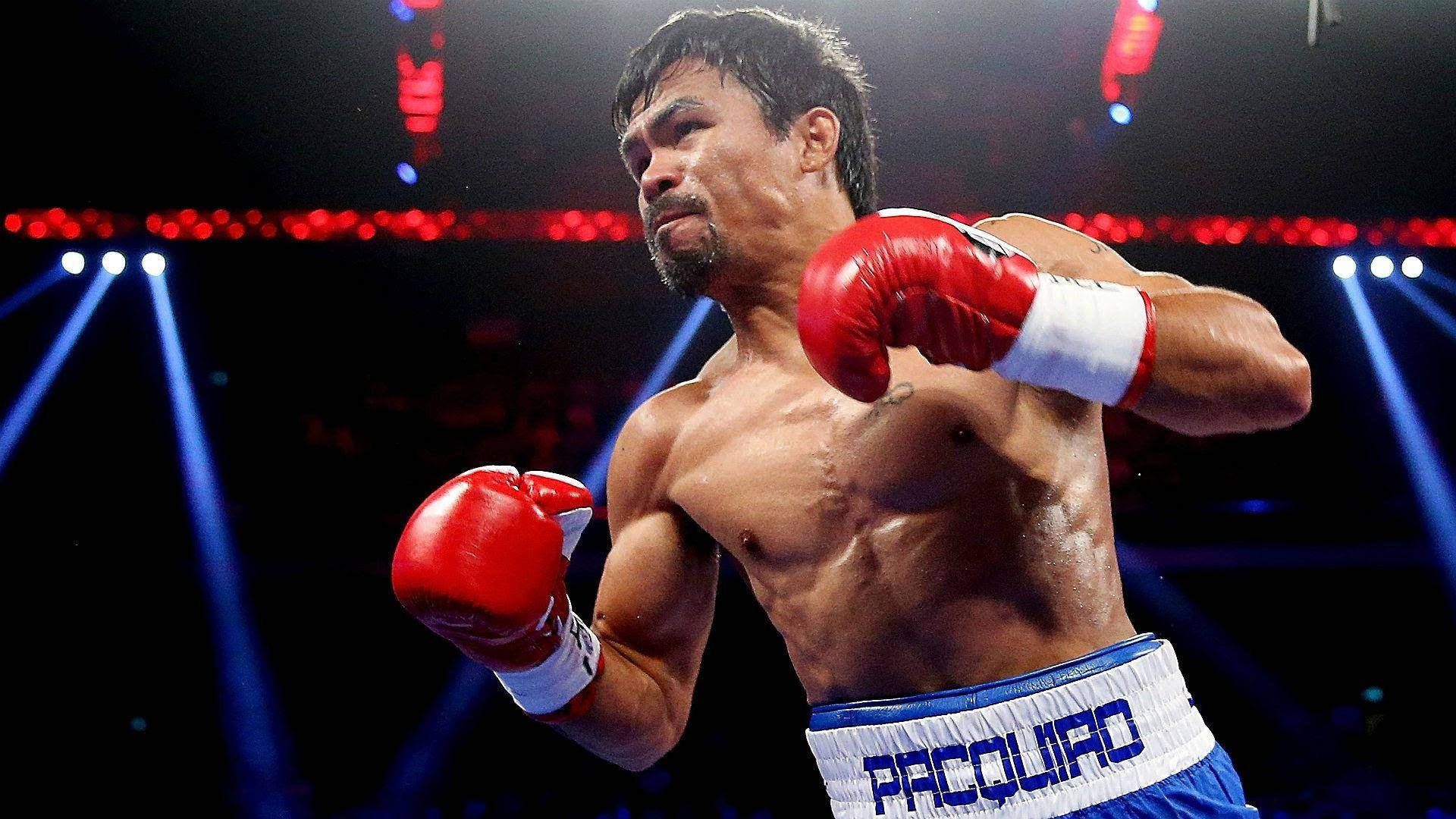 戴紅色手套的拳擊手在場館燈光下揮拳。