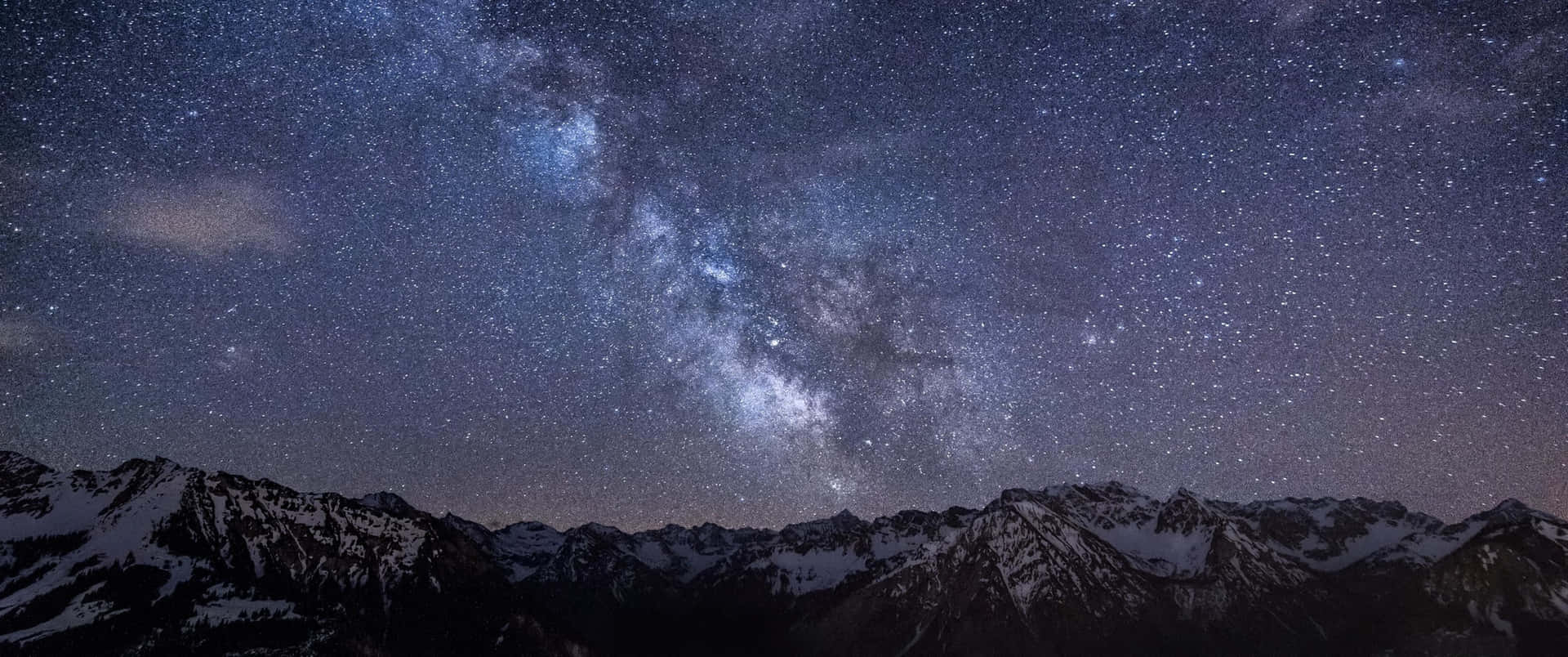在星空下積雪的山脈，銀河系清晰可見。