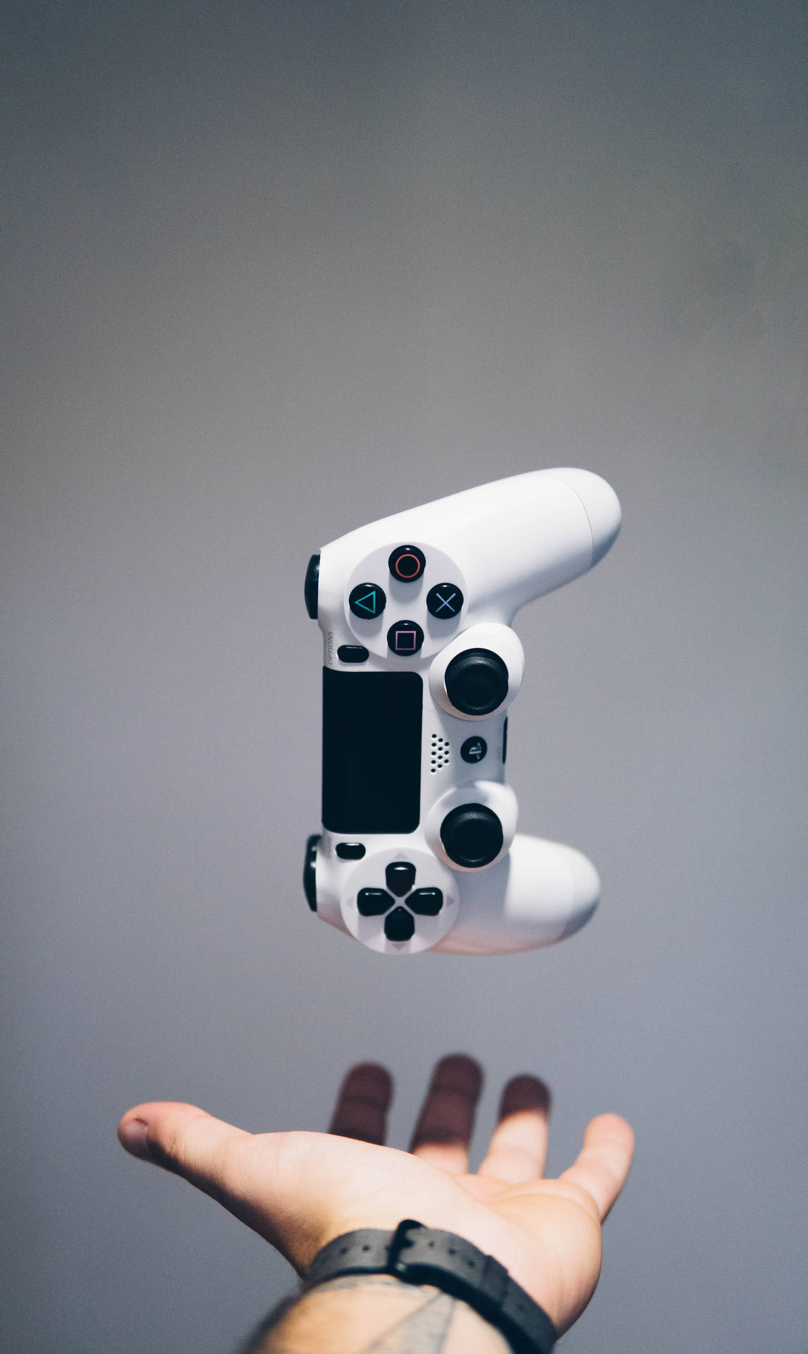 一個白色遊戲手掣在張開的手上漂浮。