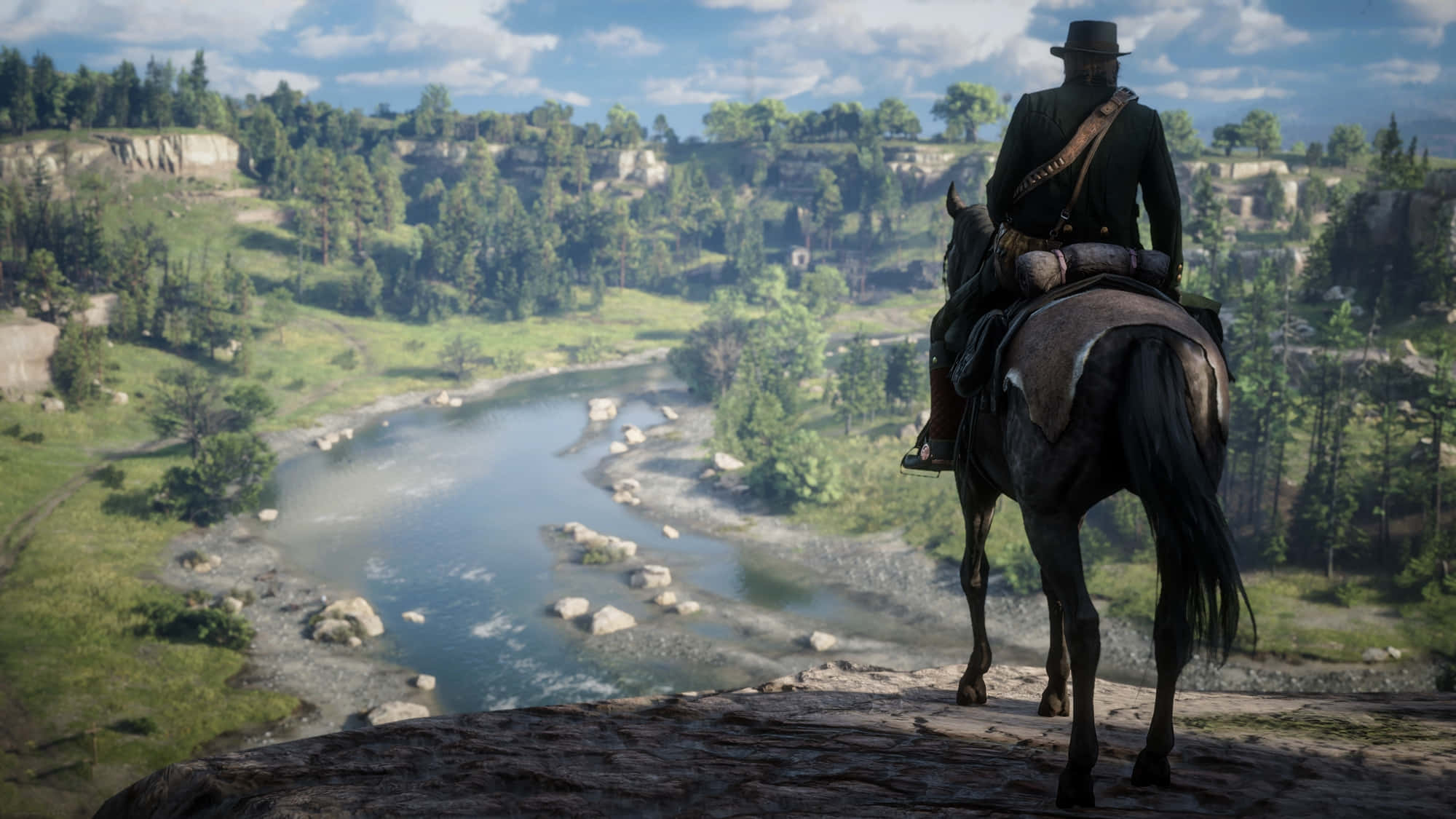 最佳《Red Dead Redemption 2》亞瑟·摩根背景 壁紙 — 一個孤獨的牛仔騎著一匹黑馬，俯瞰著蜿蜒的河流穿過鬱鬱蔥蔥的綠色山谷，頭頂是明亮的藍天。