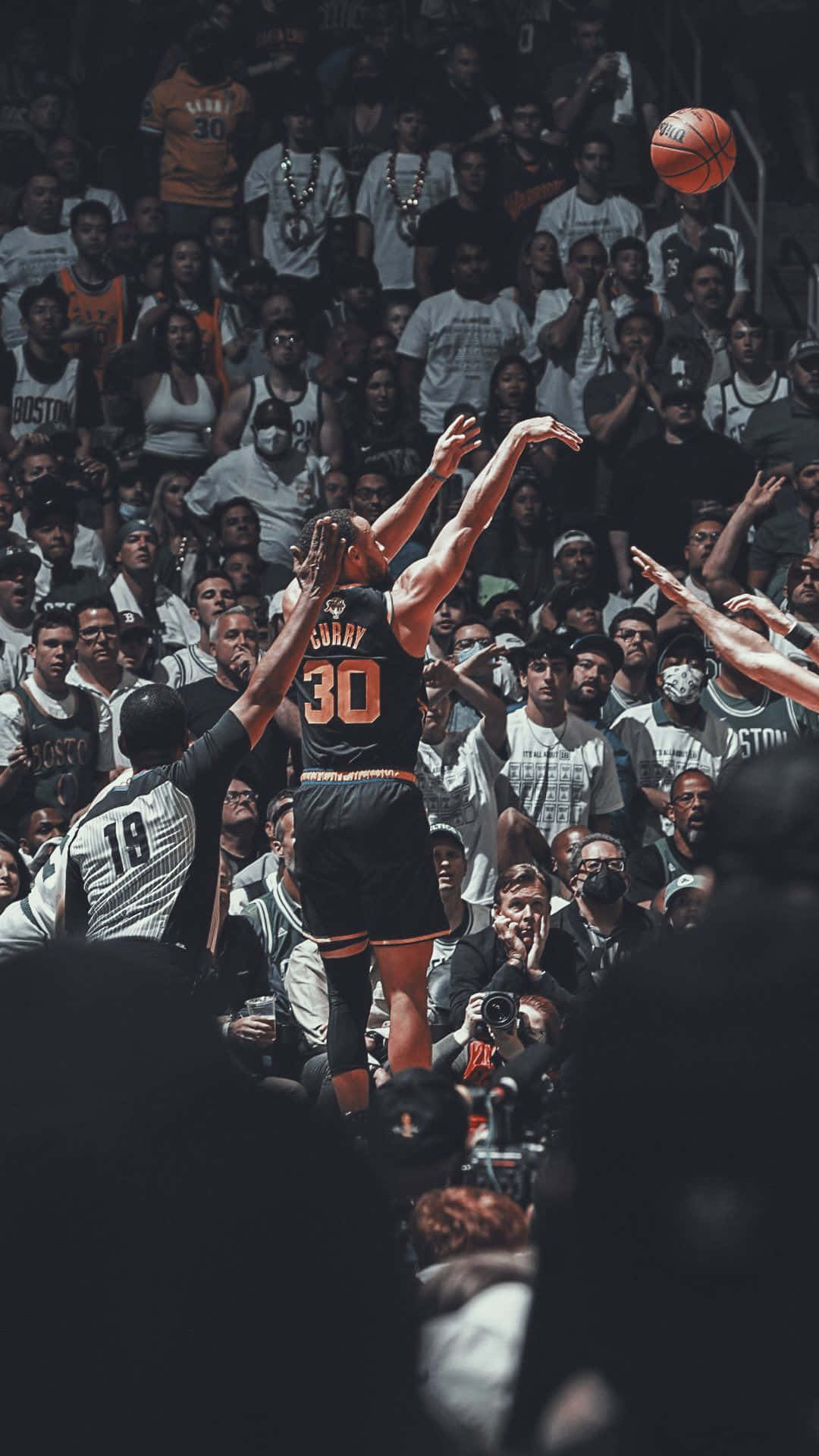 最佳NBA投籃瞬間 壁紙 — 一名身穿黑色球衣、背號30的籃球運動員跳起投籃，越過防守球員，球在空中劃出弧線飛向籃框，場館內座無虛席。