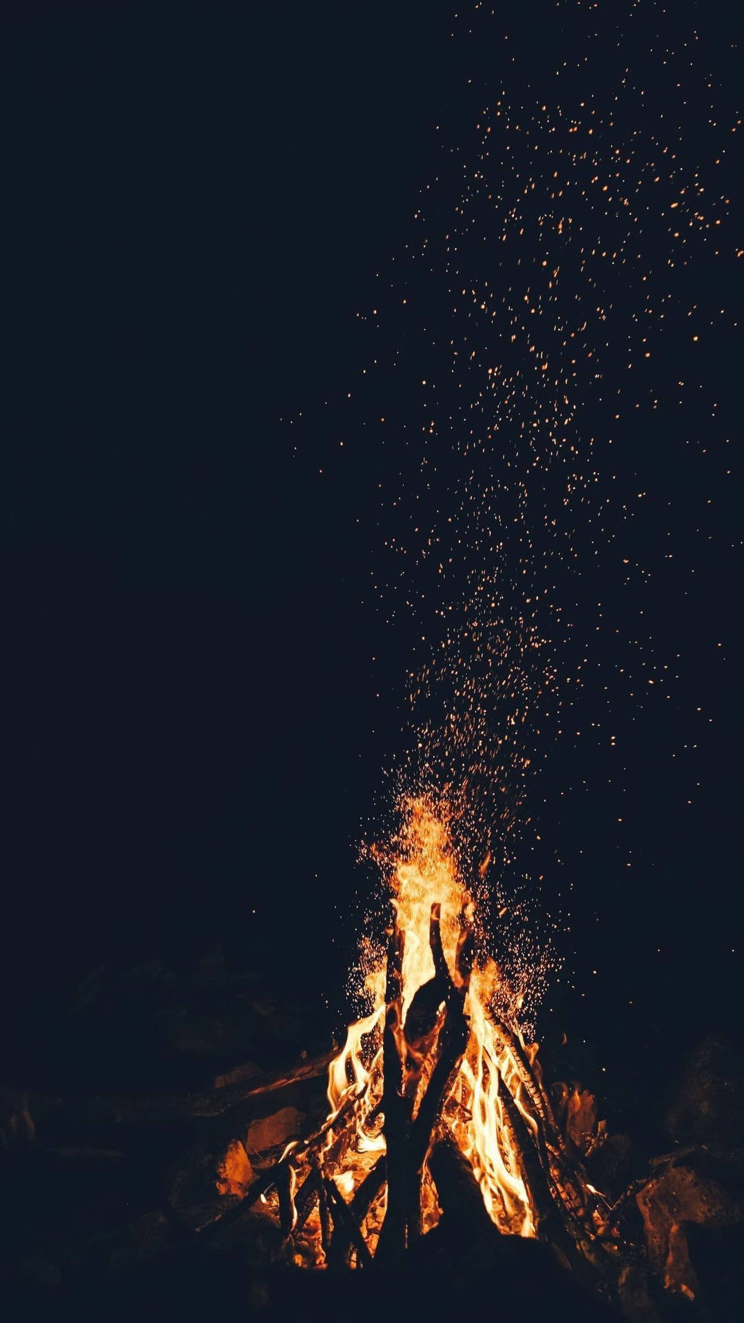 營火發光，火花升入黑暗的夜空