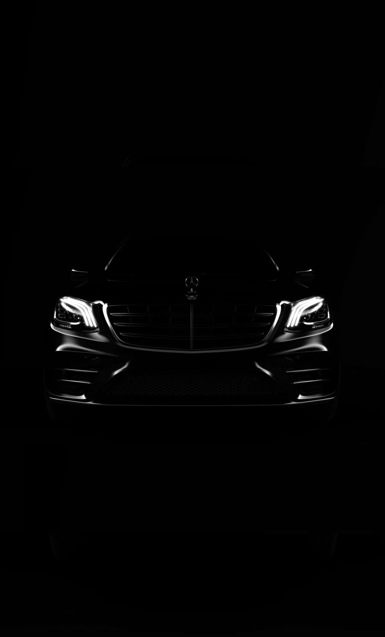 最佳梅賽德斯背景：全黑梅賽德斯於暗影中 壁紙 — 一輛時尚的Mercedes-Benz SUV，在漆黑背景下被發光的車頭燈照亮。