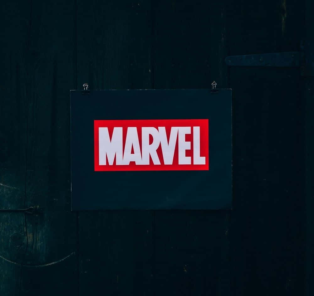 最佳漫威英雄——集合！ 壁紙 — 一個大膽的紅白Marvel標誌懸掛在帶有金屬鉸鏈的深色風化木門中央。