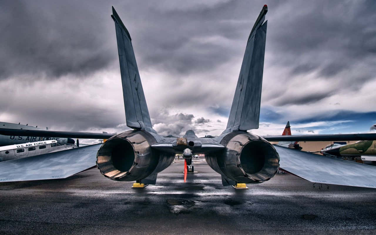 暴風雨天空下，一架戰鬥機停在濕滑的停機坪上，附近有其他飛機。