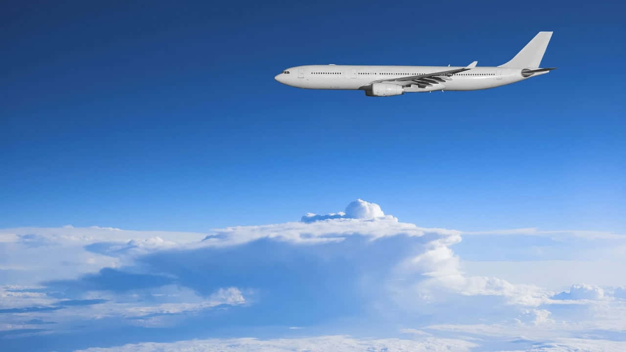 白色飛機在明亮的藍天中飛越雲層