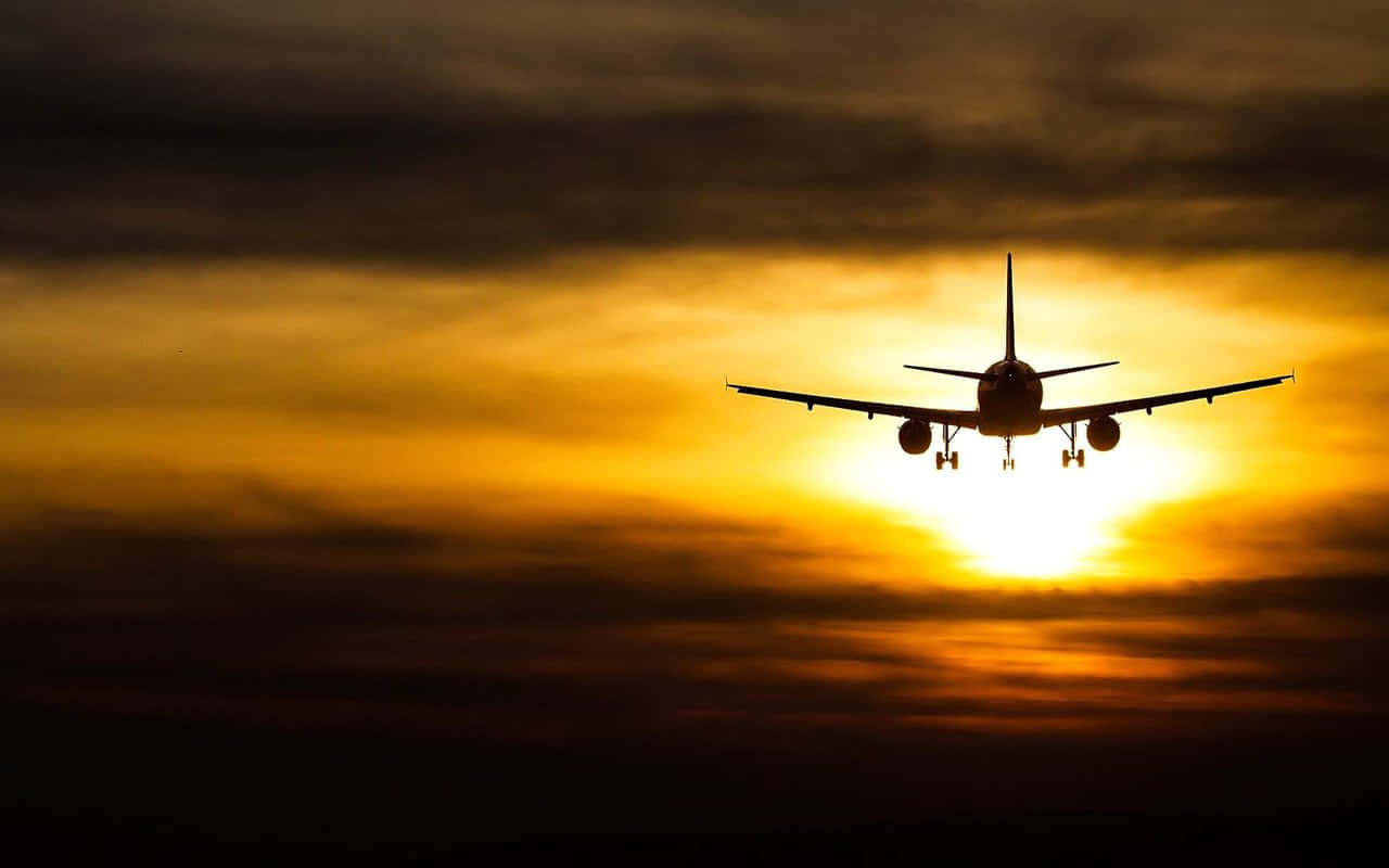 飛機飛入金色日落與雲層